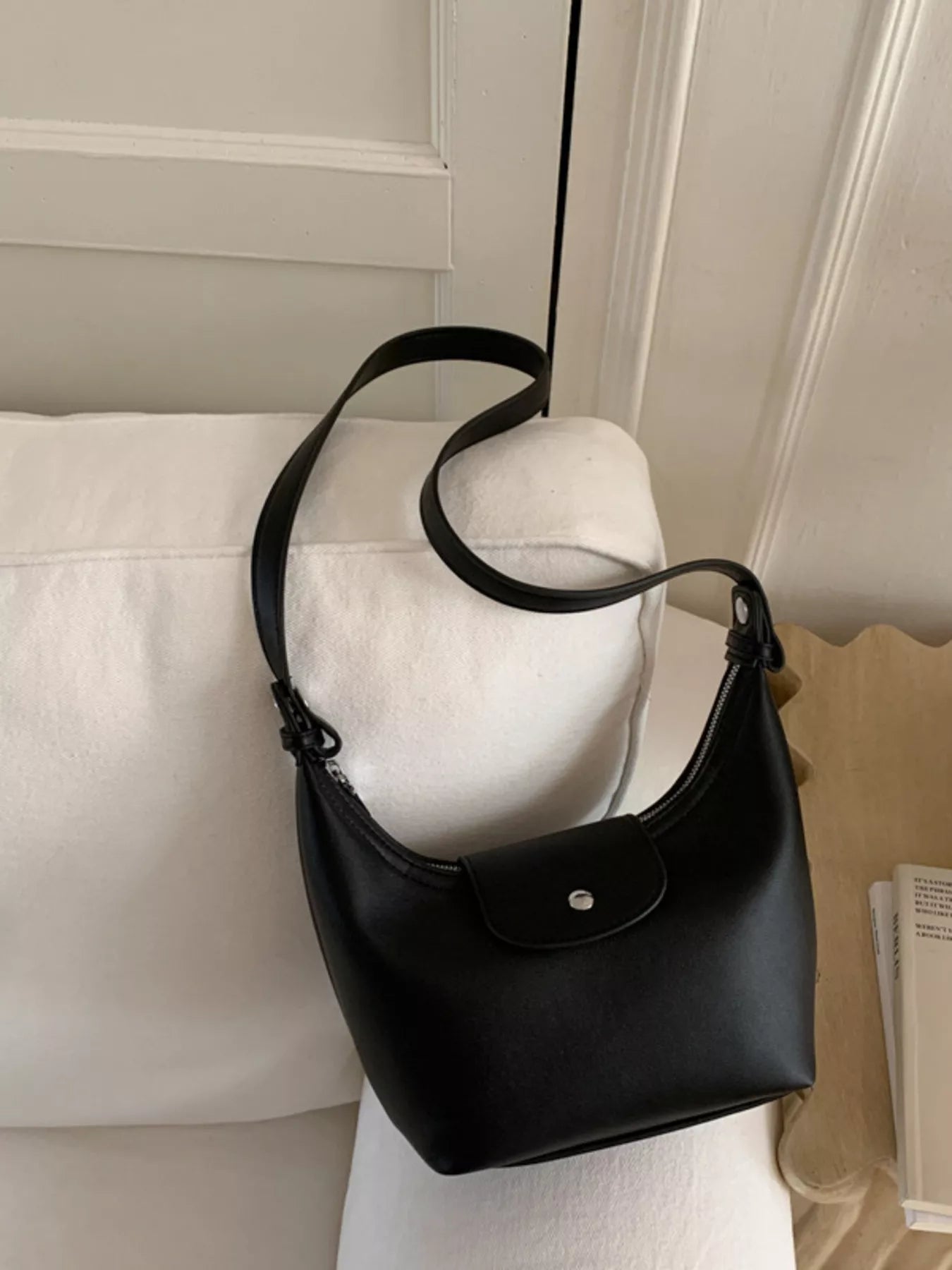 Black crescent shoulder bag with short strap and front snap pocket