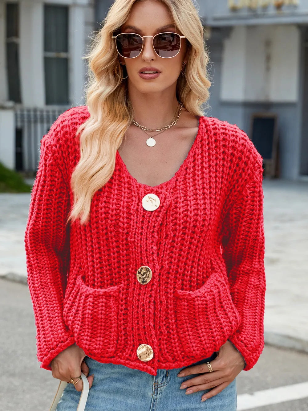 Red knit cardigan with round neckline and button front, patch pockets