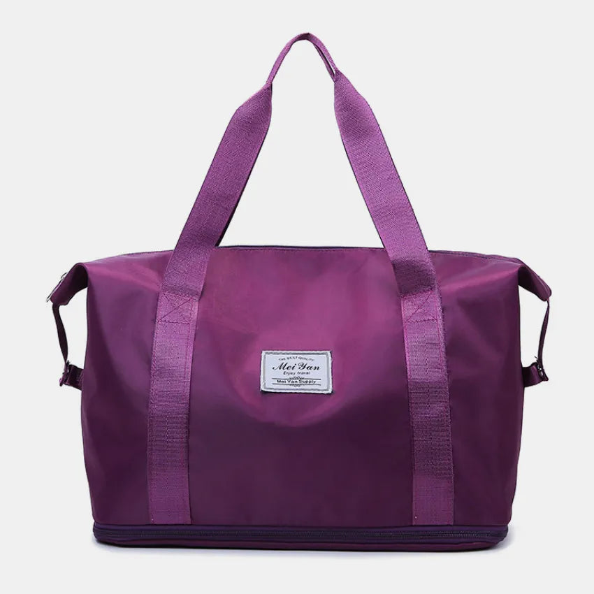 Plum purple large duffle bag with long handles and front patch label