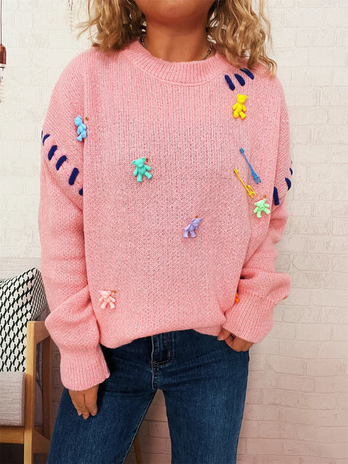 Pink round-neck knit sweater with colorful animal/applique graphics on front and sleeves