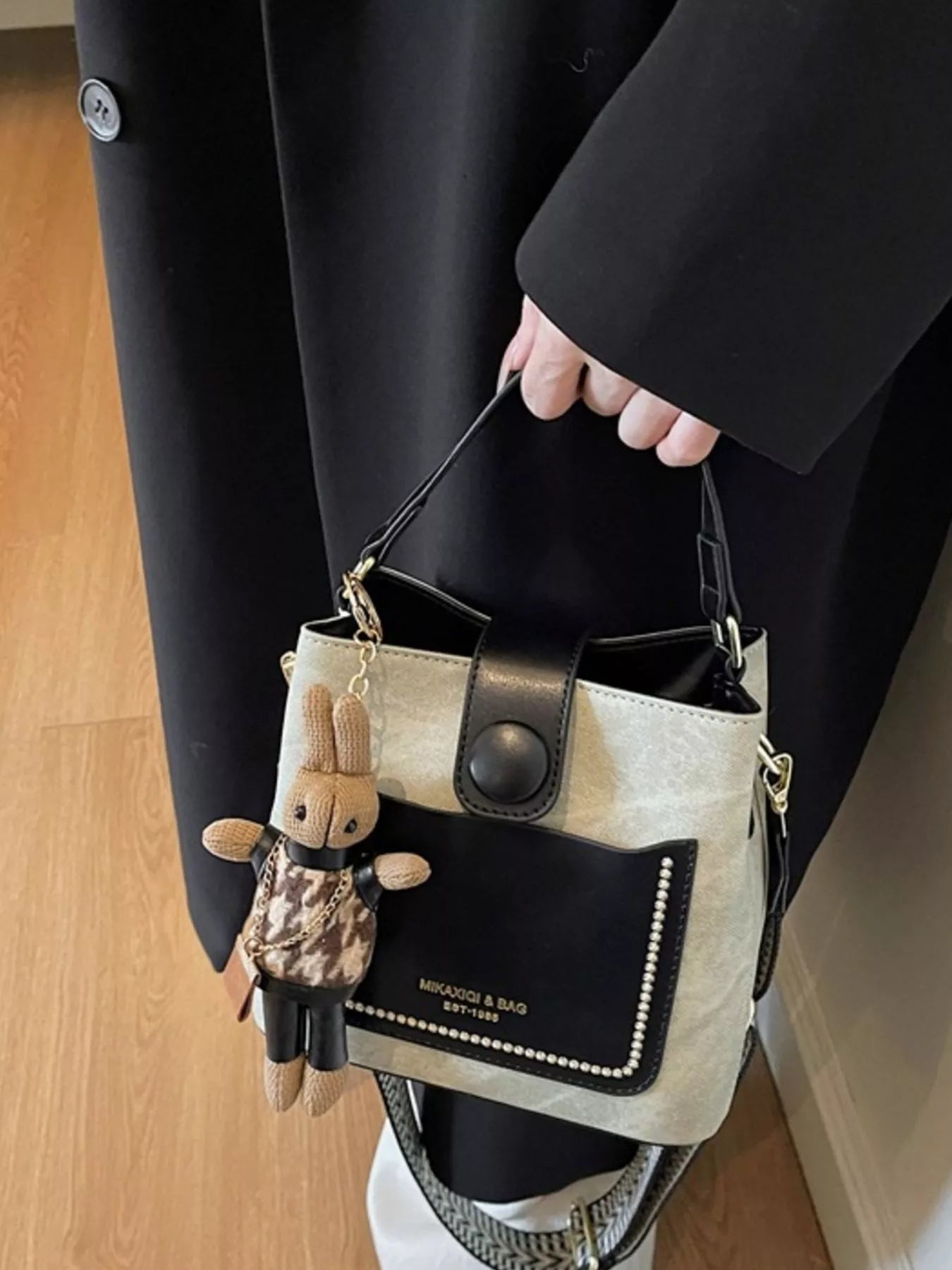 Two-Tone Bucket Crossbody Bag, small cream PU with black front pocket and gold hardware.