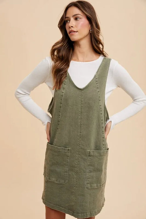 Army green denim overall dress with V-neck and two patch pockets, front view
