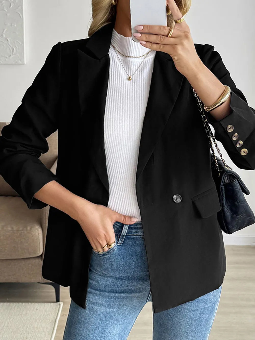Black long sleeve blazer with buttoned flap pockets and notched lapels