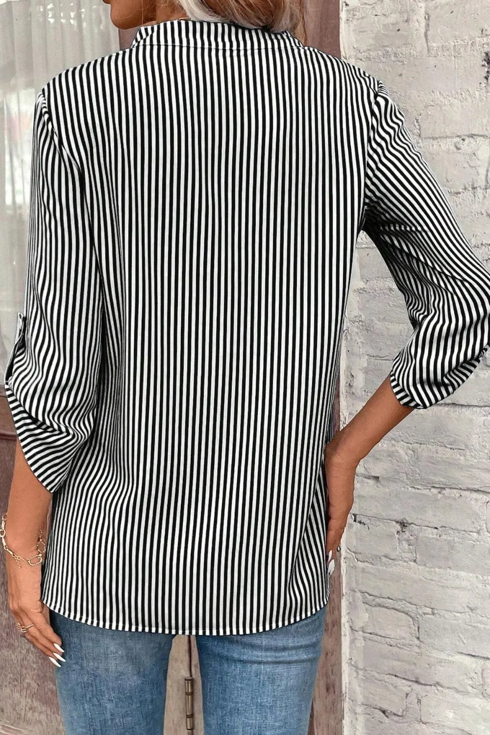 Black-and-white striped roll-tab sleeve shirt from the back with vertical stripes