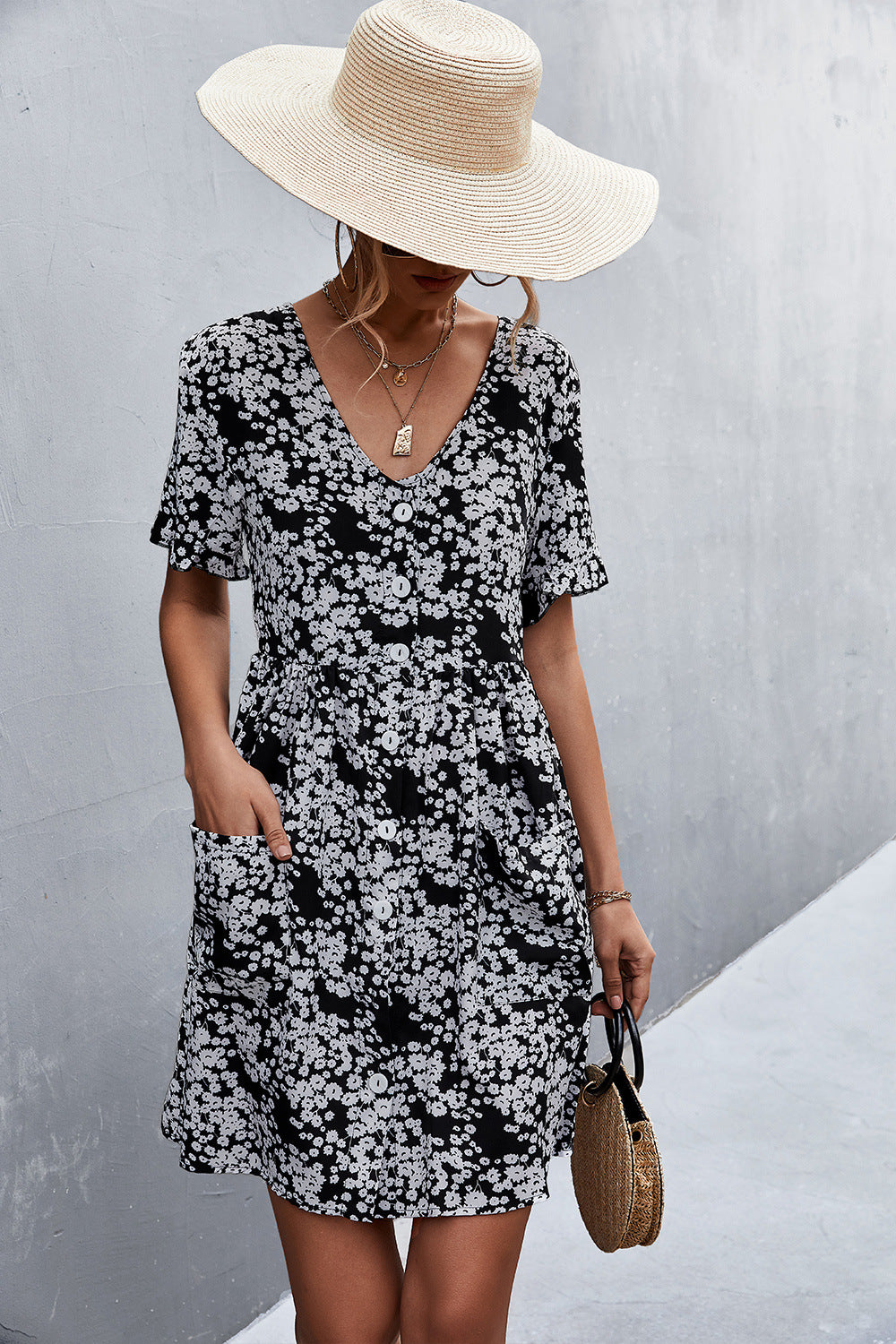 Black floral printed button-front dress with V-neck and patch pockets, short-sleeve style.