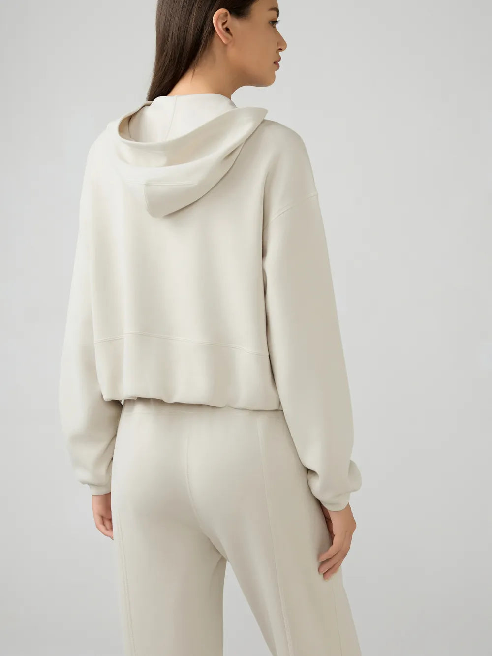 Cream zip-up hooded jacket, back view with hood and dropped shoulders