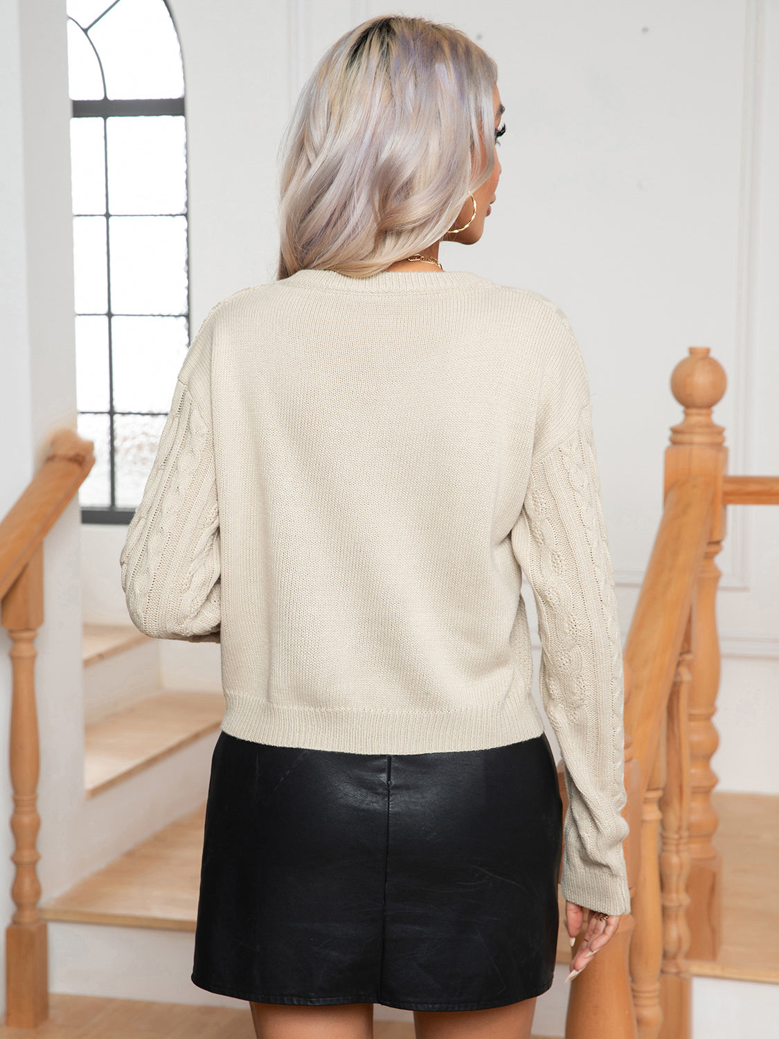 Ivory cable-knit round-neck sweater, back view, long sleeves and ribbed hem and cuffs