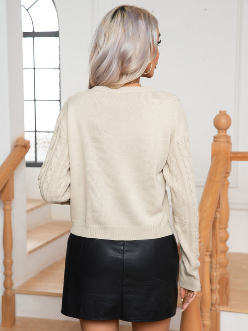 Ivory cable-knit round-neck sweater, back view, long sleeves and ribbed hem and cuffs