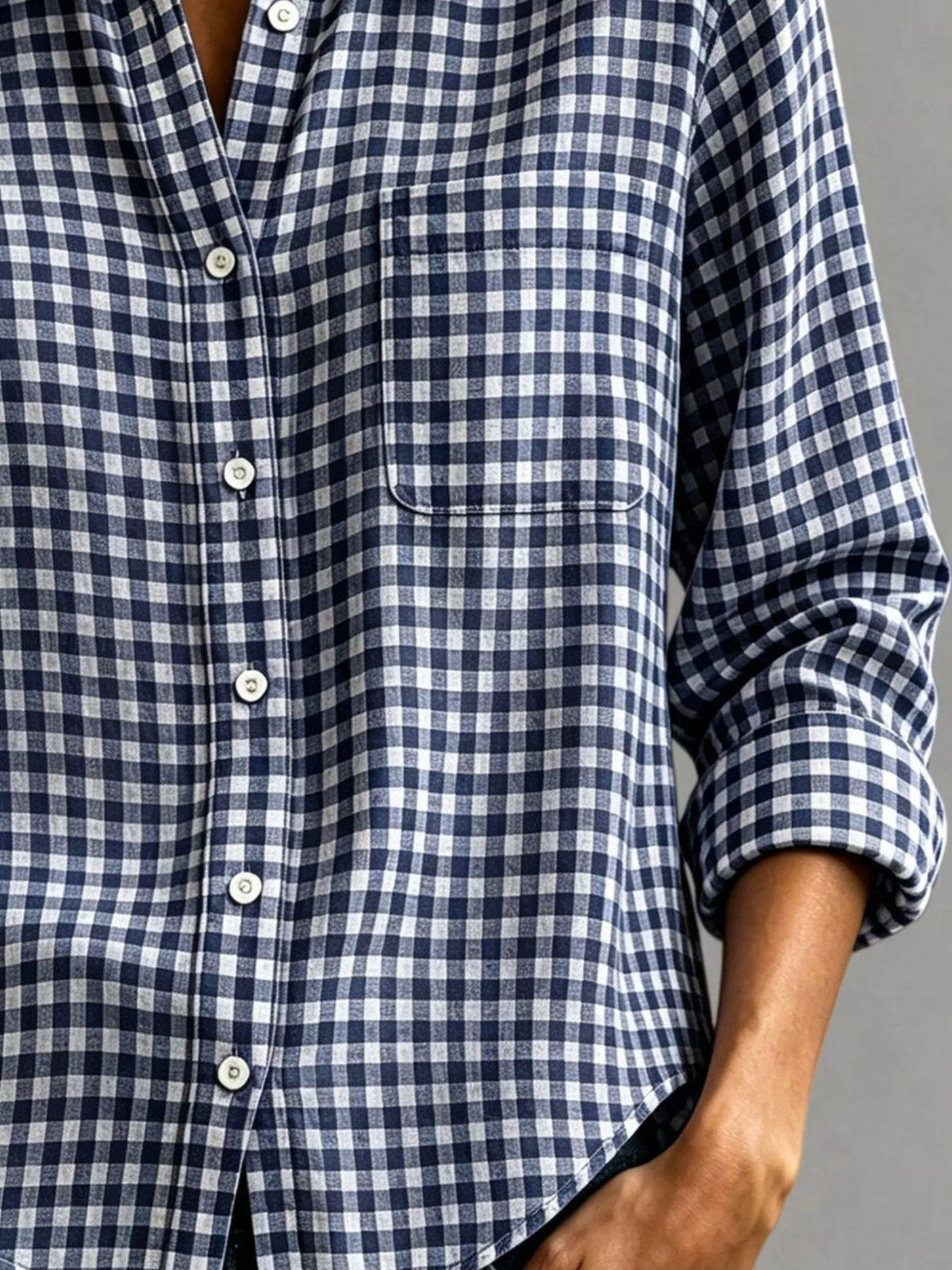 Navy-and-white gingham button-down shirt with chest pocket, long sleeves, and cuff buttons.
