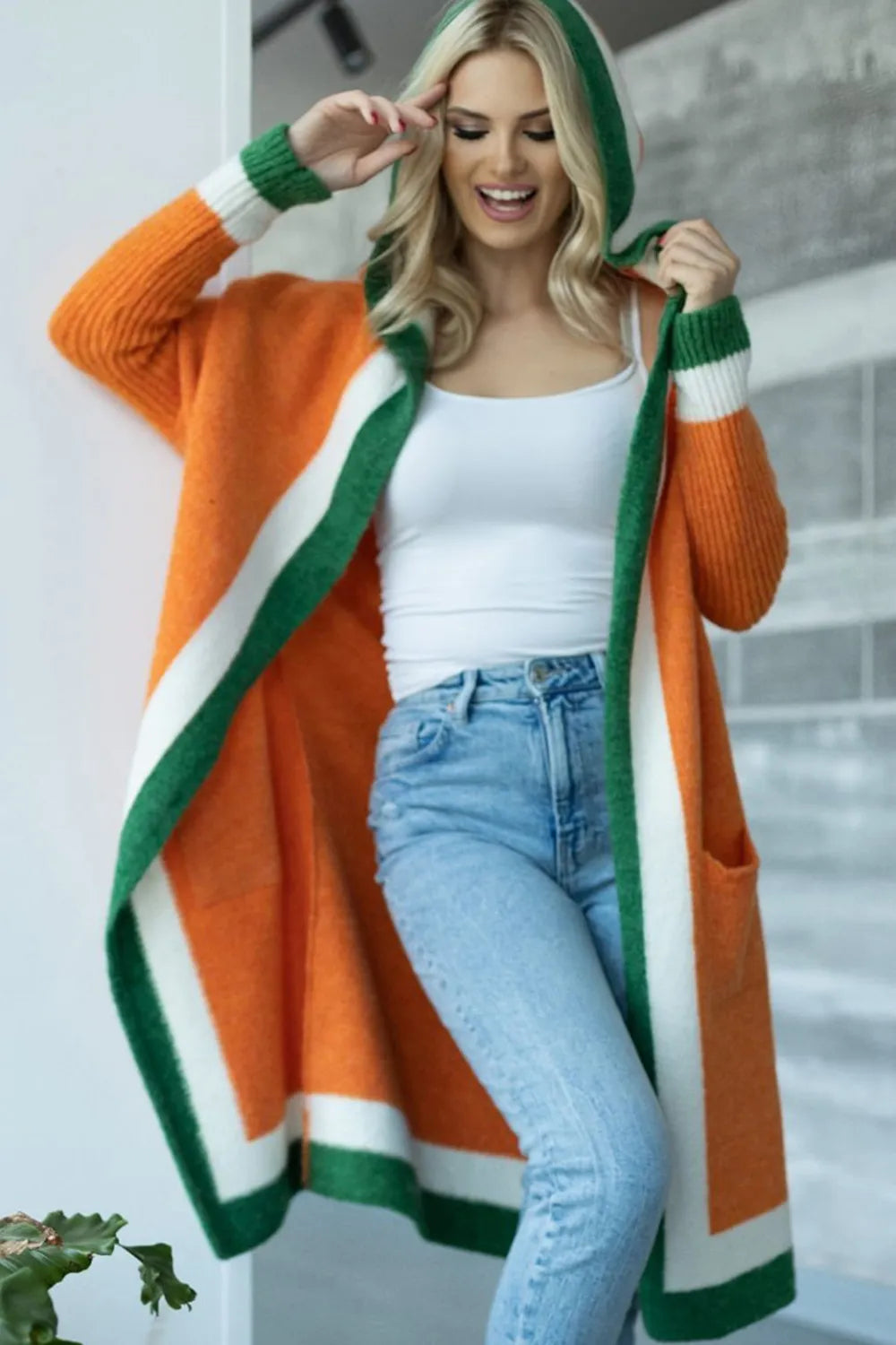 Orange hooded cardigan with green-and-white striped contrast and front pockets