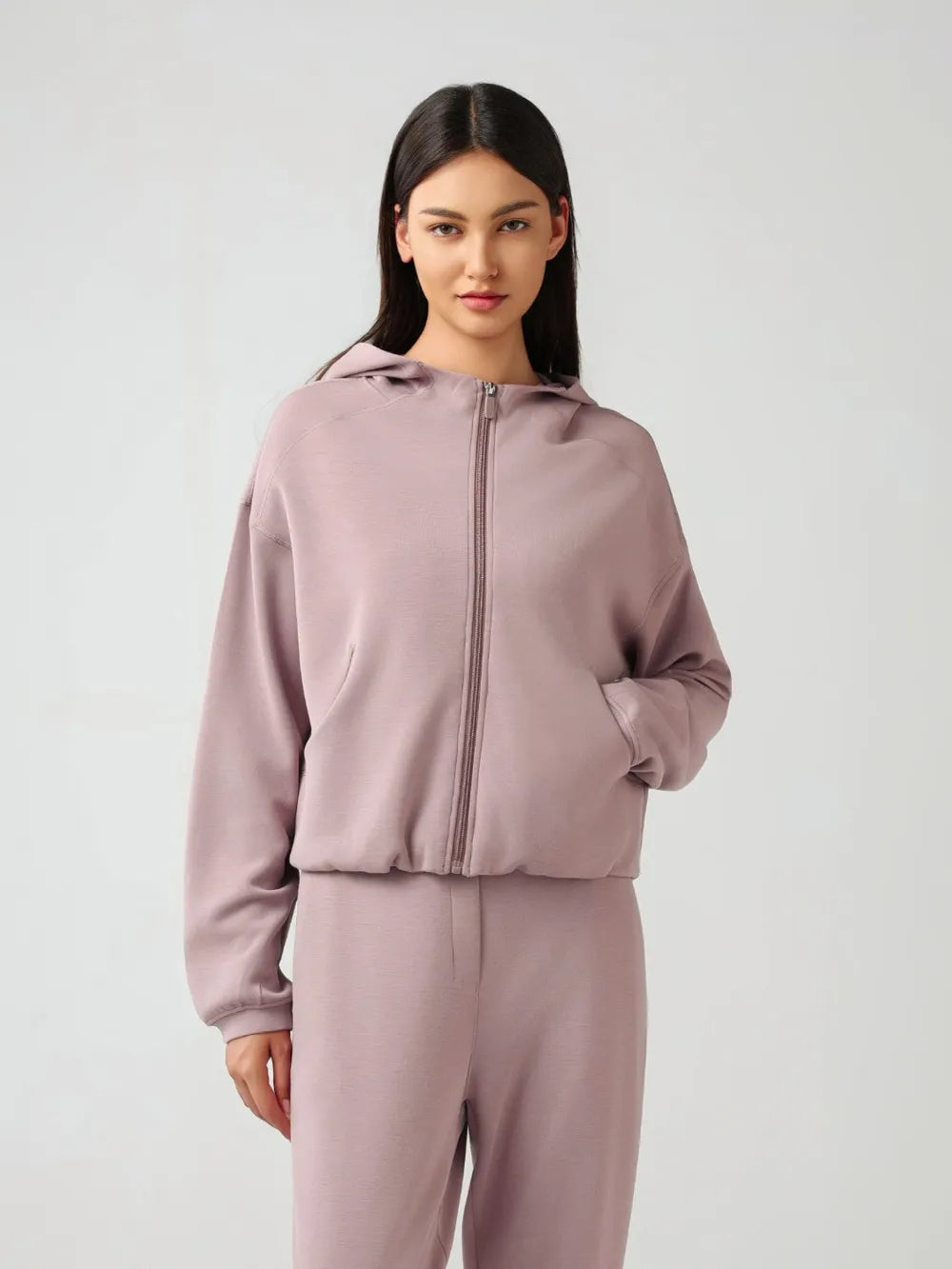 Dusty pink zip-up active hoodie with hood and full front zipper, relaxed dropped-shoulder style