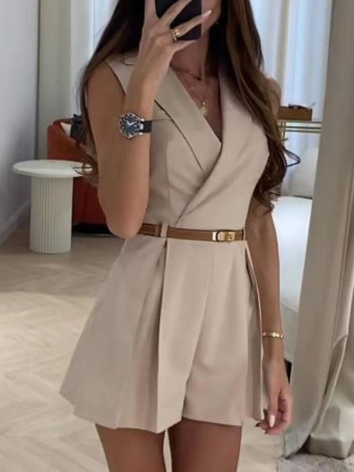 Apricot sleeveless surplice romper with belted waist and pleated skirted shorts
