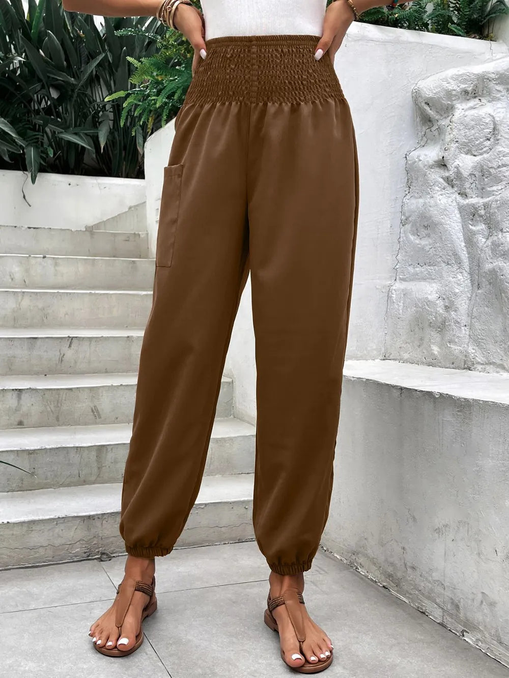 Brown smocked high-rise joggers with side pockets and relaxed tapered legs