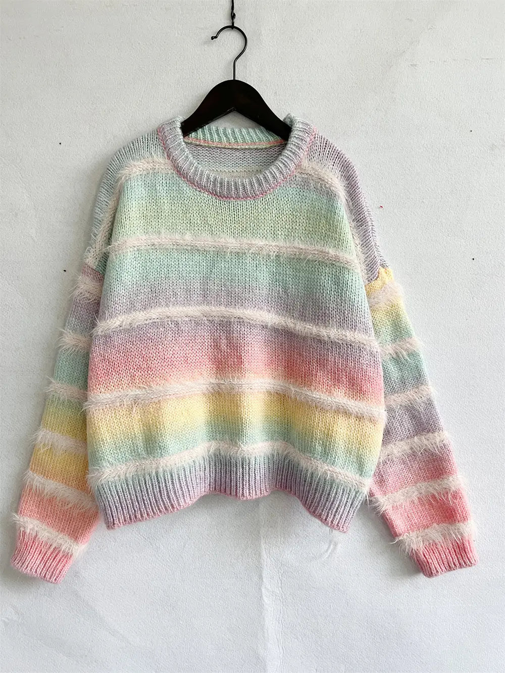 Striped round-neck long-sleeve sweater on a hanger, pastel aqua, pink, and yellow stripes