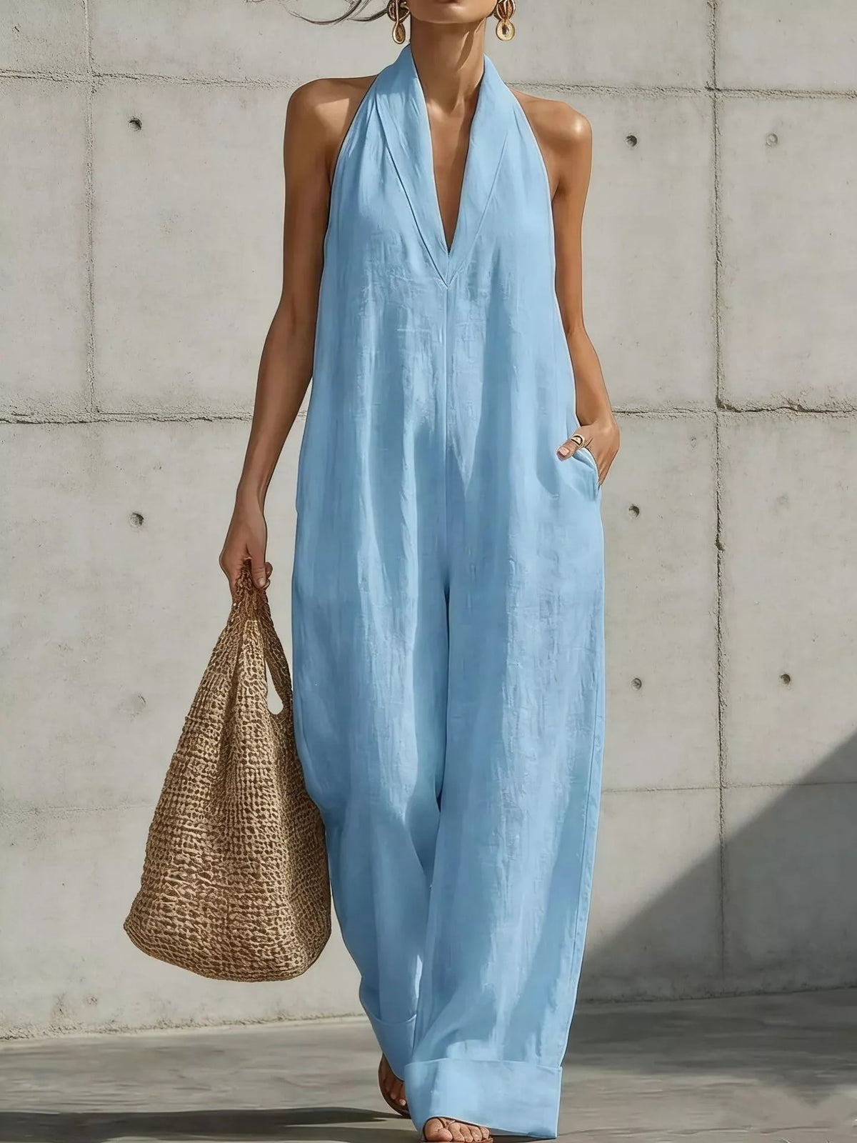 Sky blue halter-neck wide-leg jumpsuit with deep V neckline, sleeveless halter and flowing wide legs.