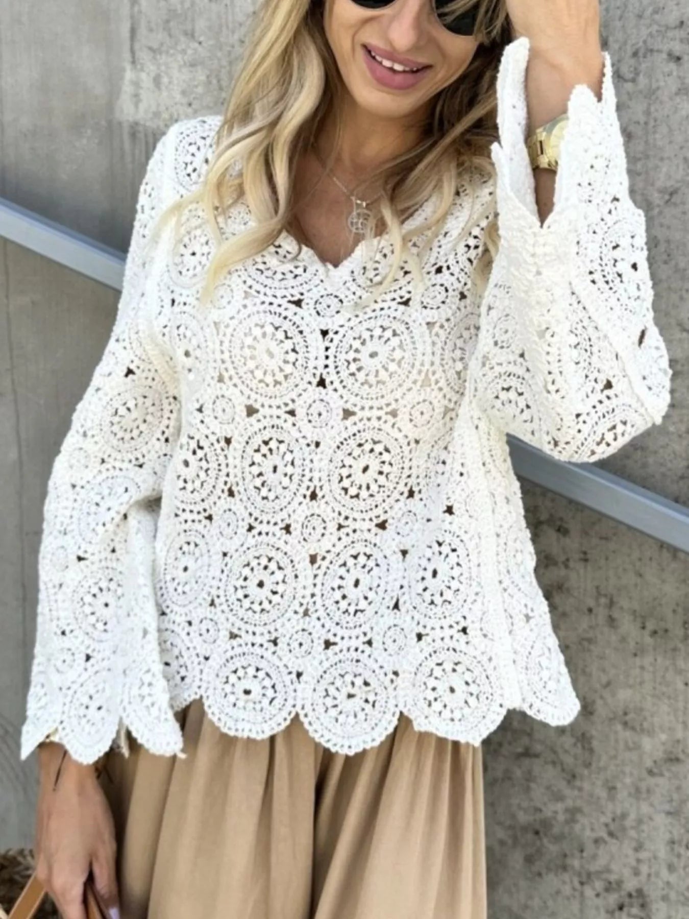 White crochet lace knit top with V-neck, long bell sleeves, and scalloped hem