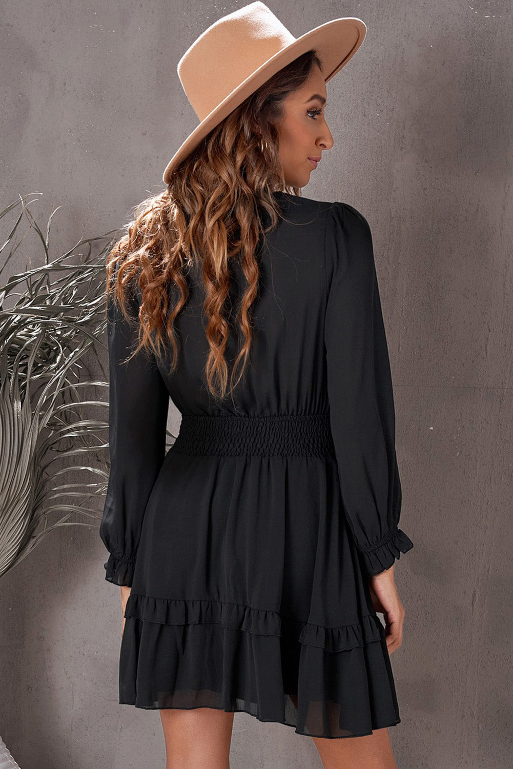 Black long-sleeve tiered flounce dress with smocked waist, shown from side/back