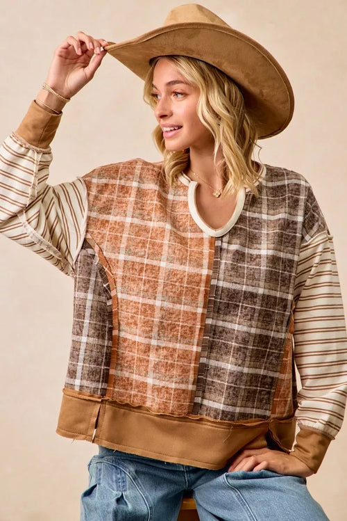 Patchwork long-sleeve top in rust and dark plaid with striped sleeves and V-neck