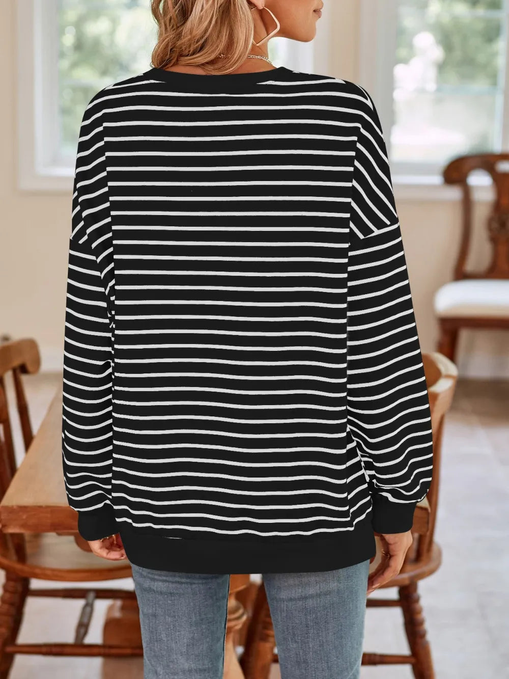 Back view of black striped crew-neck long-sleeve sweatshirt with white horizontal lines