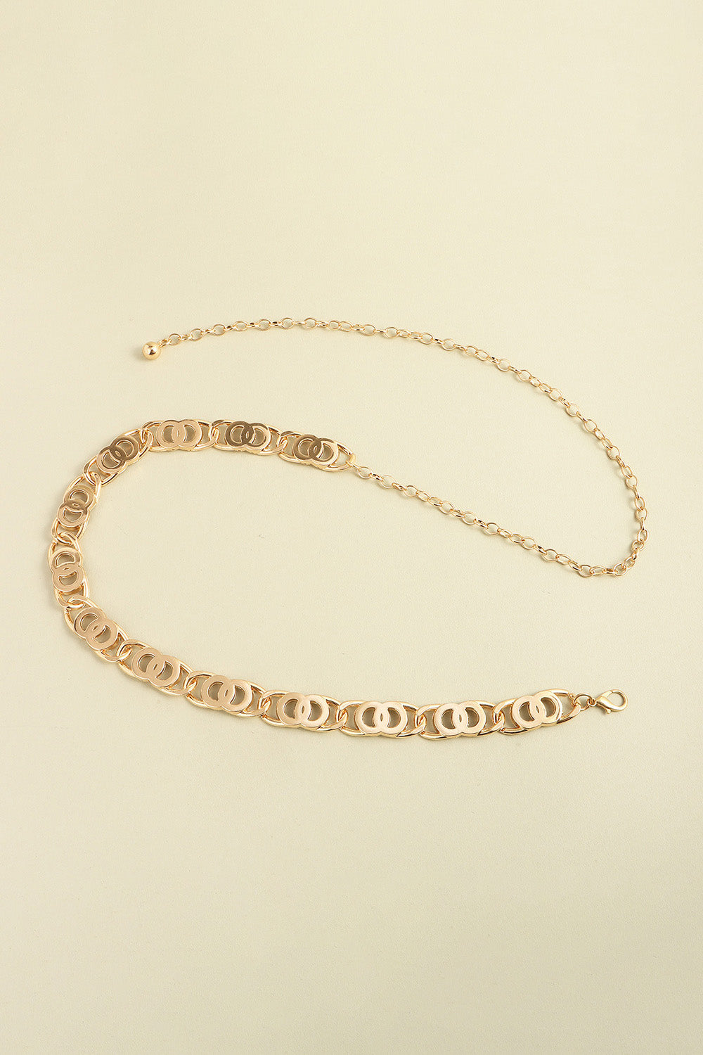 Gold lobster clasp belt with long oval-link chain and ornate center segment