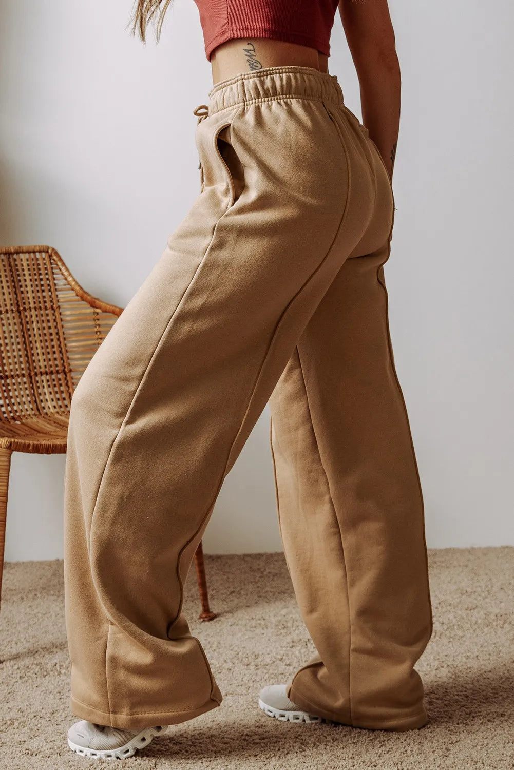 Tan wide-leg drawstring pants with side pockets and a tapered back fit