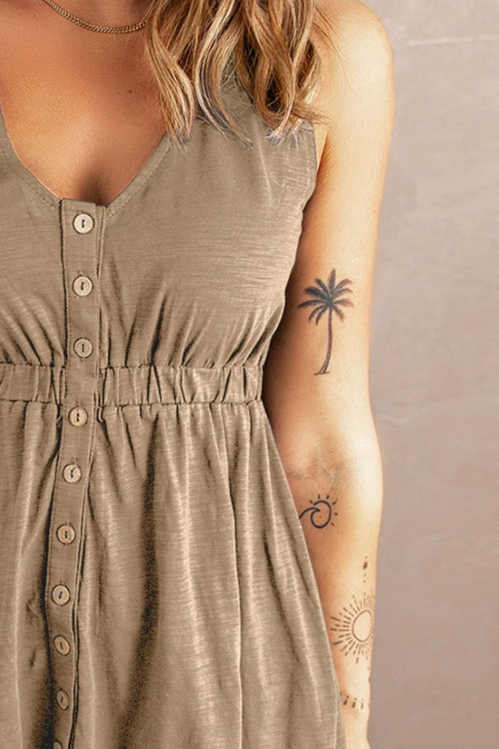 Close-up of brown sleeveless mini dress neckline with V-shape and front buttons