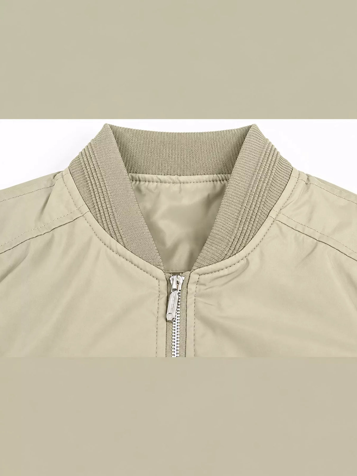 Close-up of light khaki bomber jacket collar with front zipper