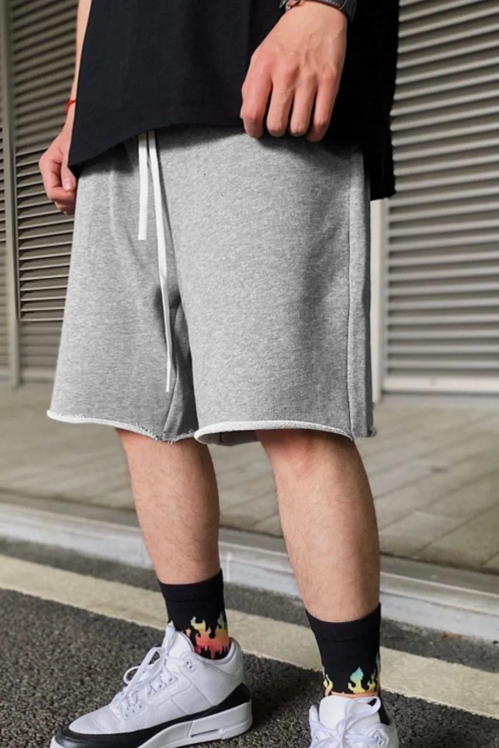 Gray drawstring shorts with elastic waistband, side pockets, and above-knee hem.