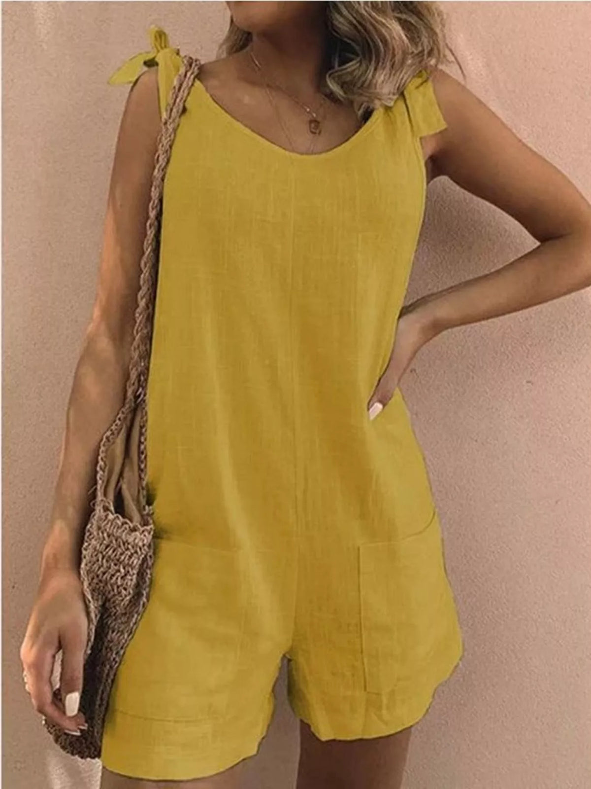 Yellow tie-shoulder bow romper with pockets, mid-waist, sleeveless.