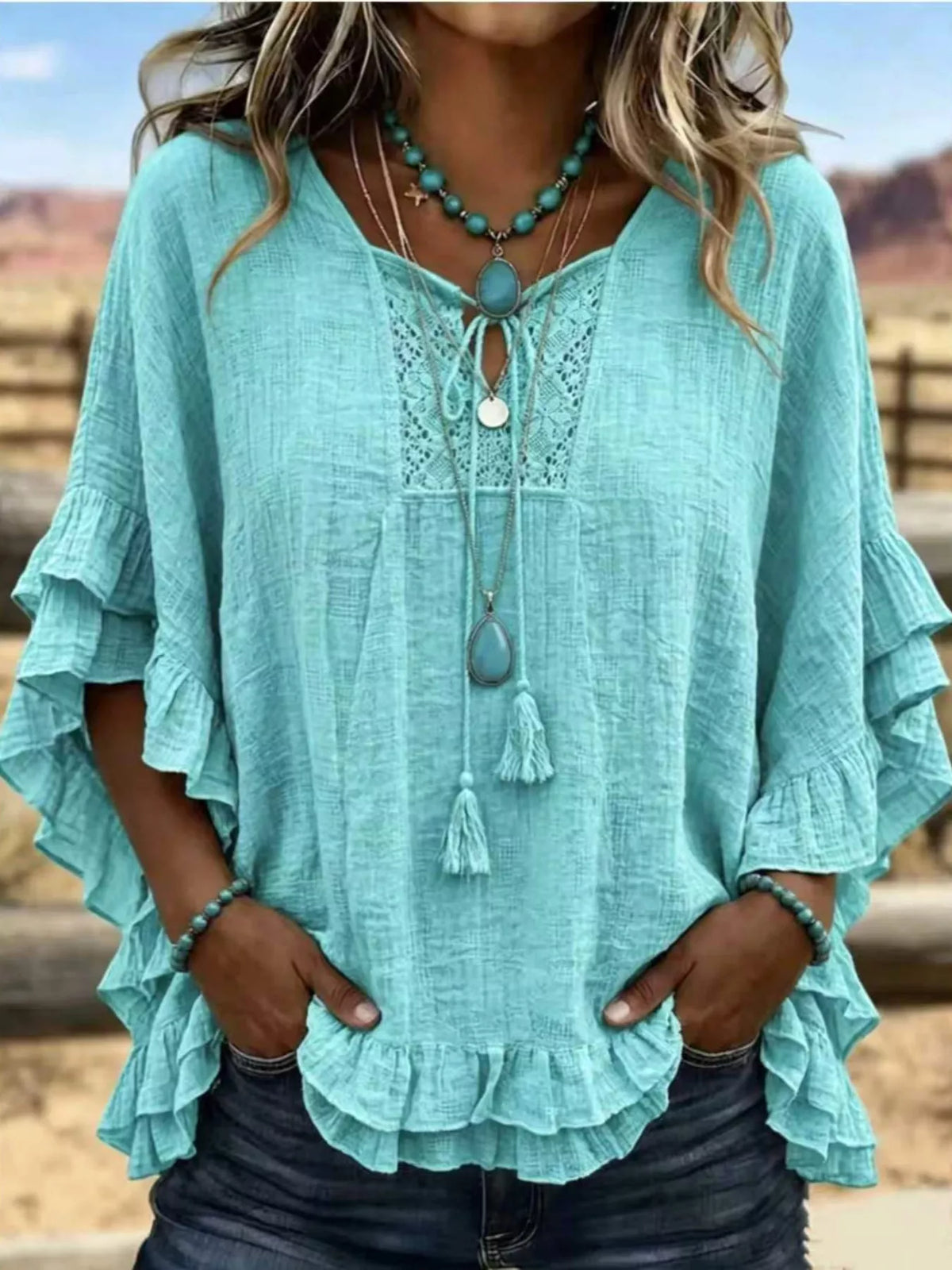 Turquoise tie-neck polyester blouse with ruffled hem and lace yoke detail