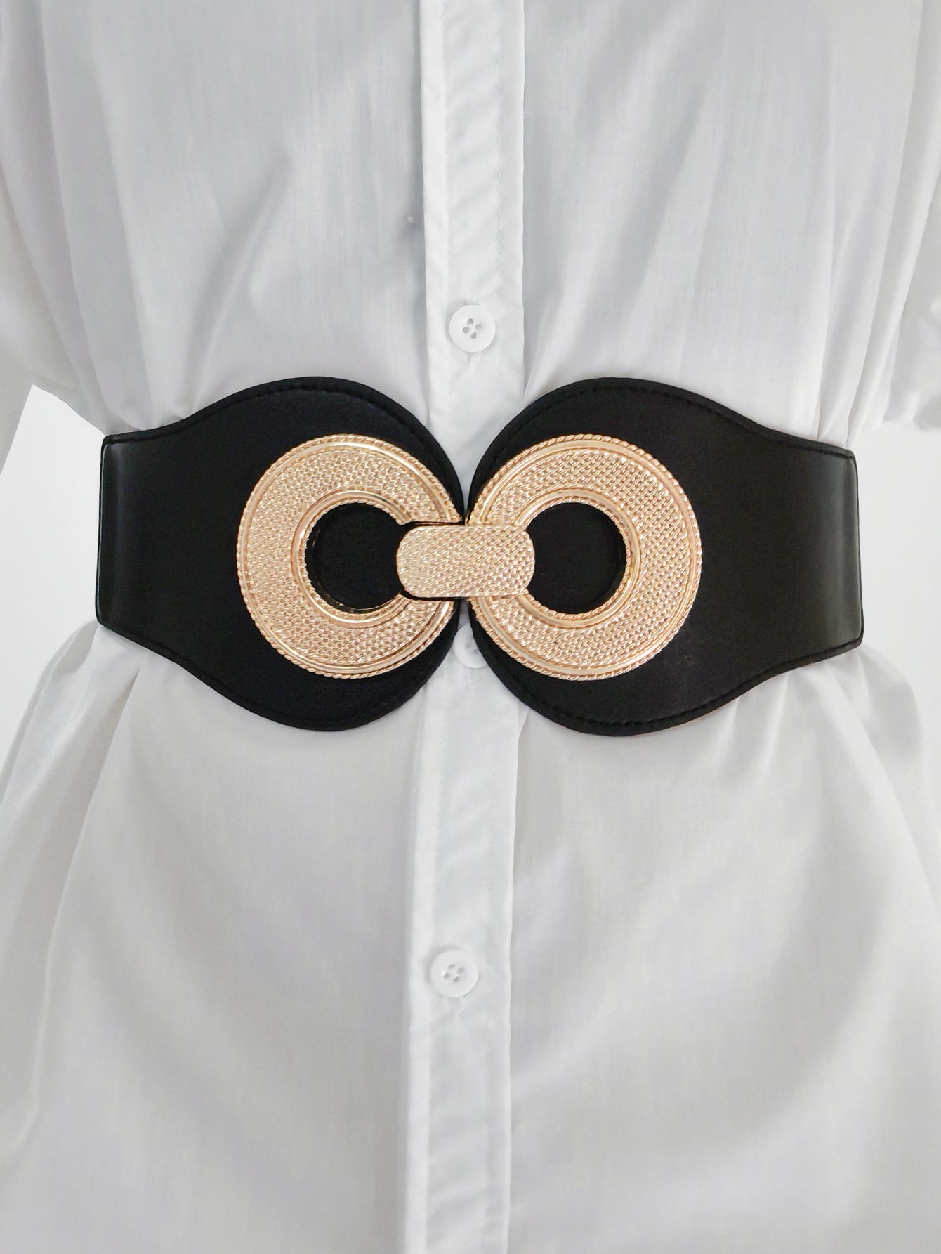 Elastic vegan belt featuring a black band with gold woven double-ring buckle