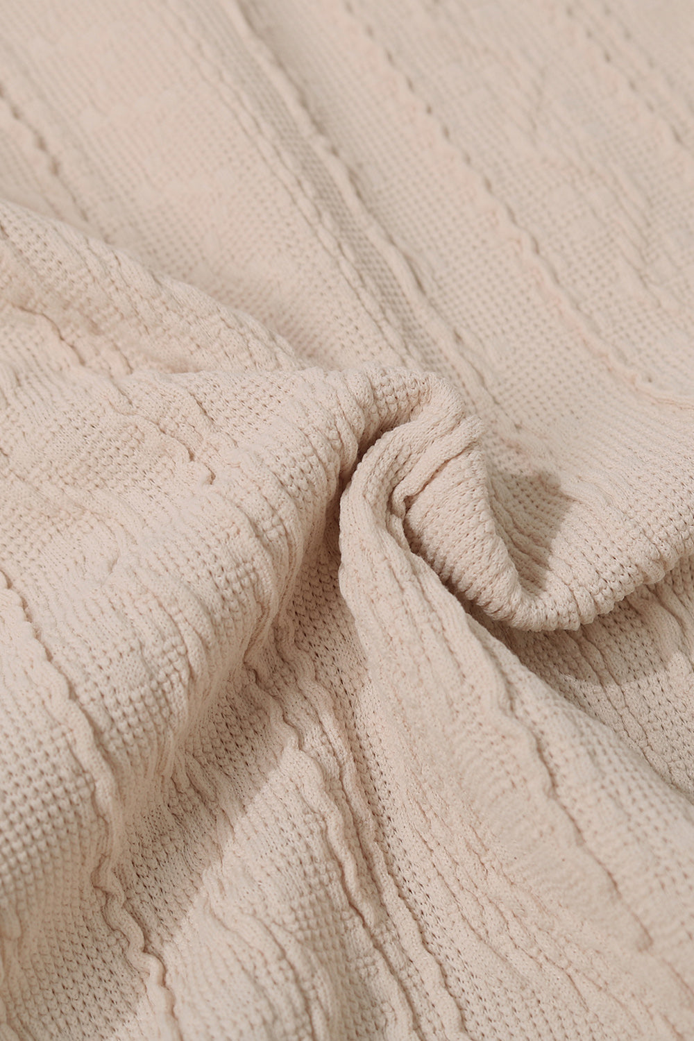 Tan textured knit fabric close-up with cable pattern