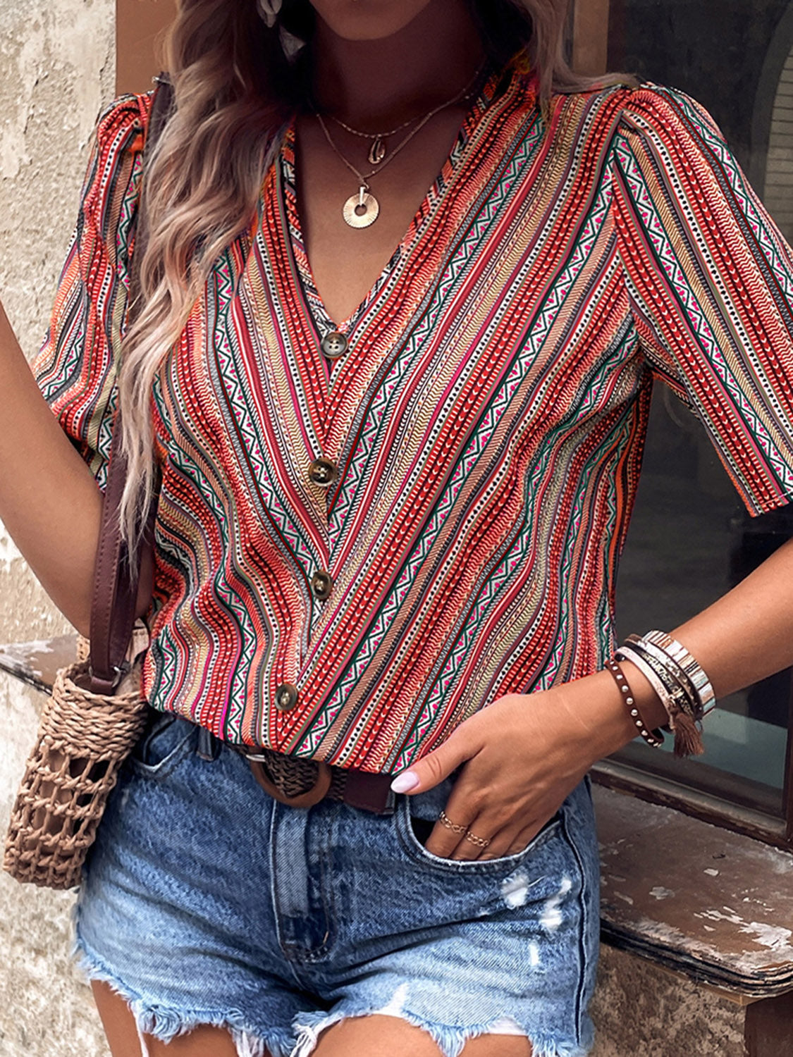 Shiny printed v-neck button-up short sleeve top, front view, red and teal vertical stripes