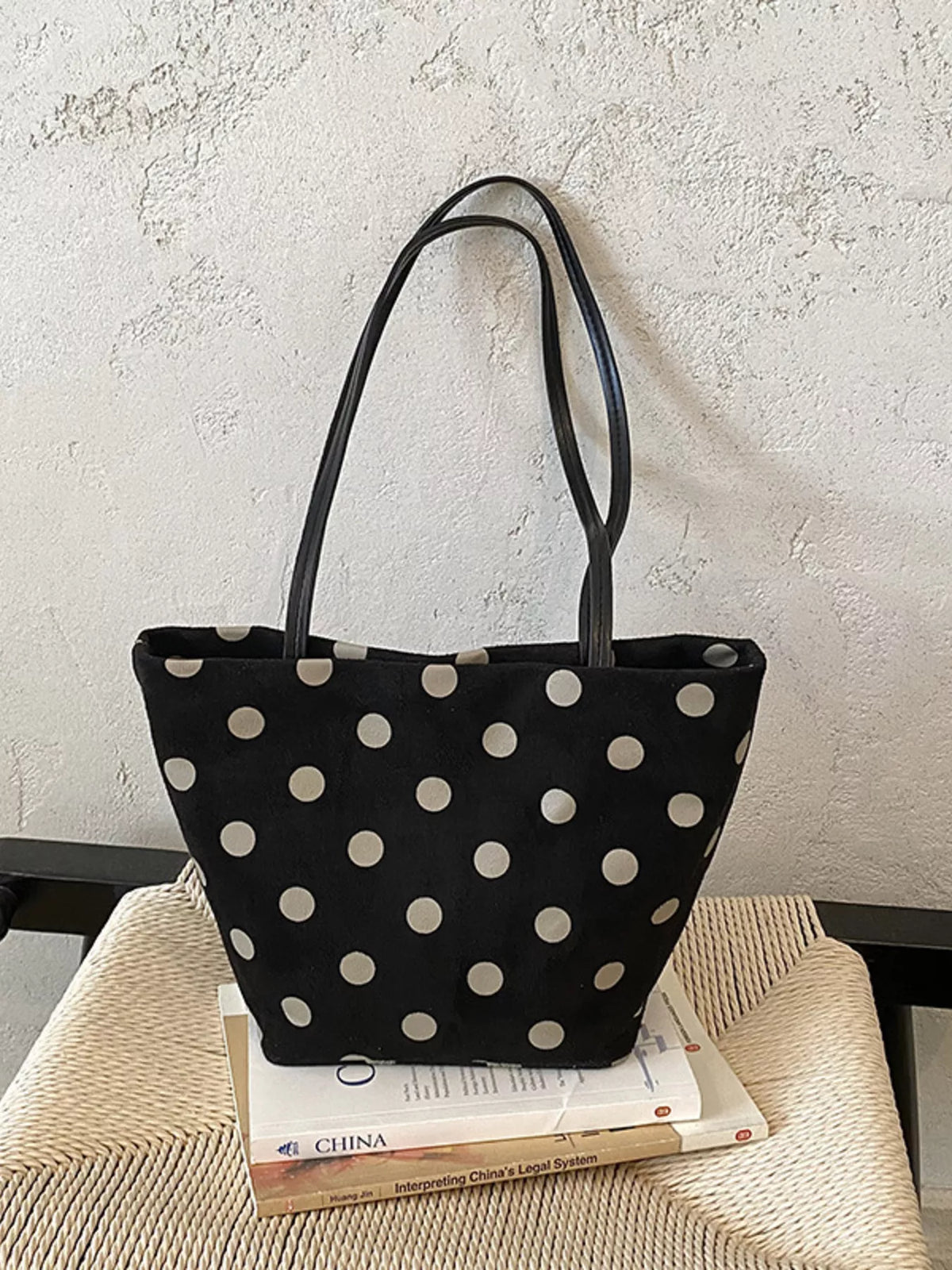 Black polka dot suede tote handbag with two top handles and cat charm