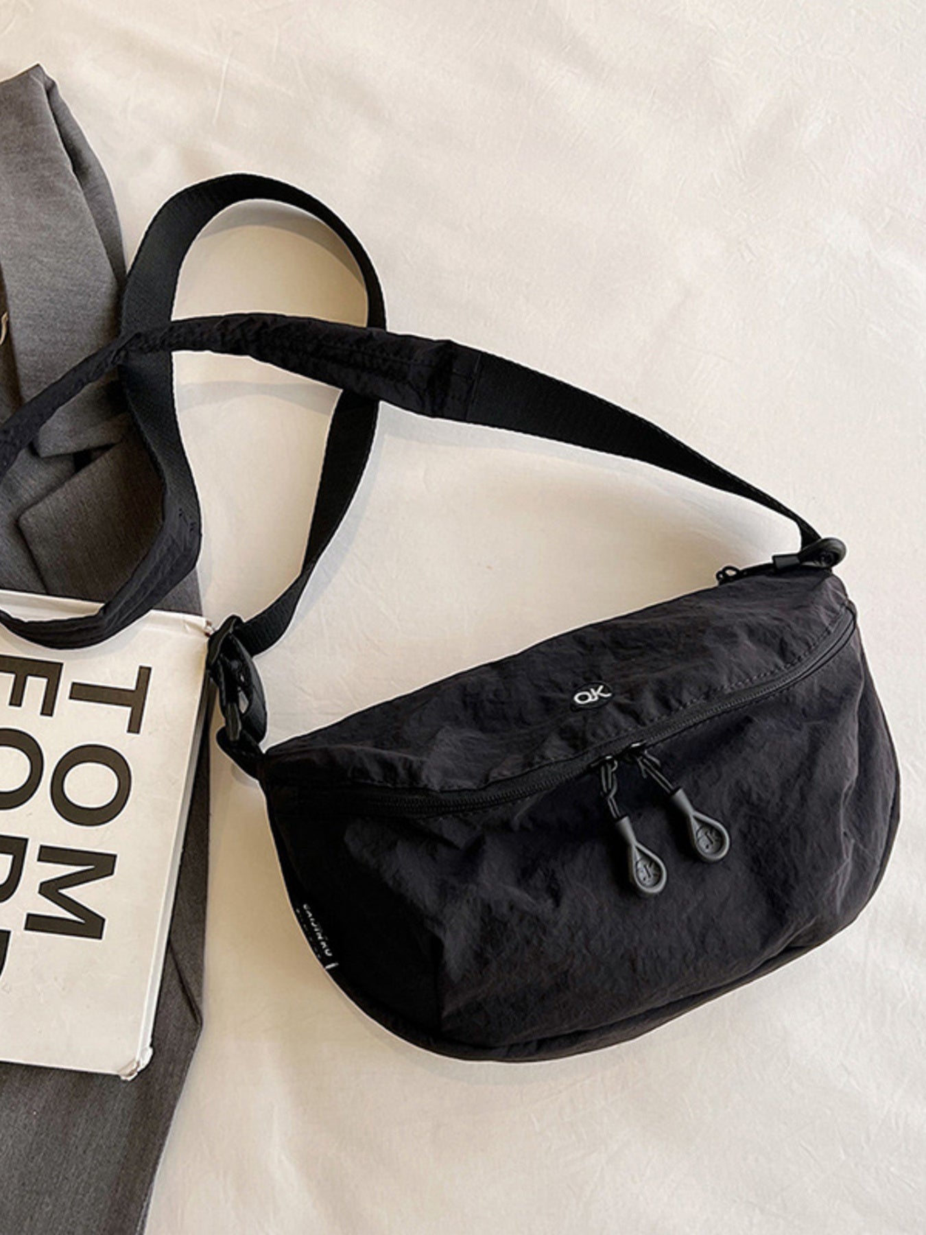 Lightweight nylon crossbody bag, black, medium size, with adjustable strap and dual zipper pulls.