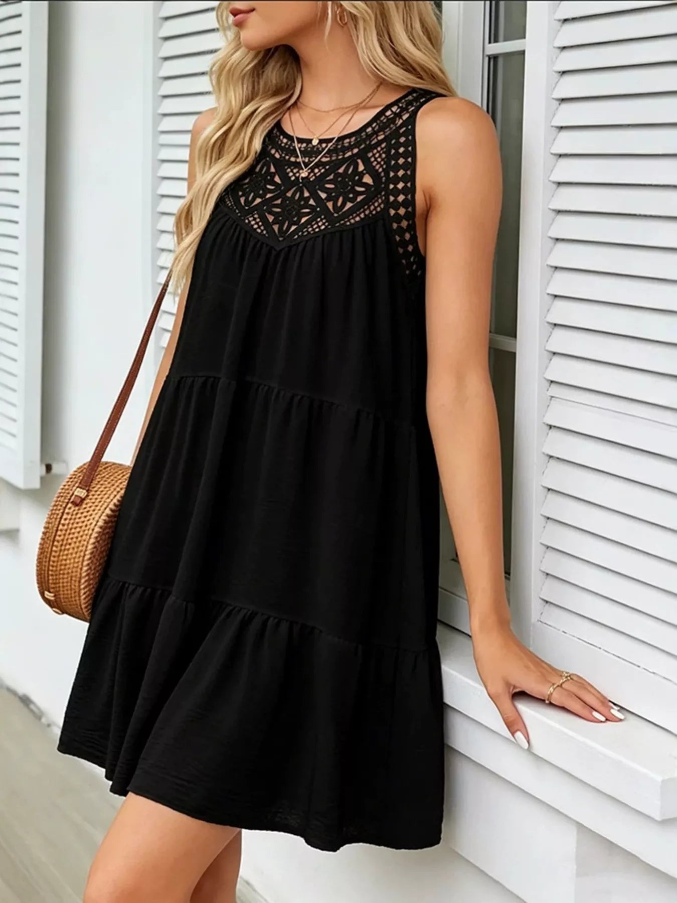 Black sleeveless lace-detail dress with round neckline and tiered layers