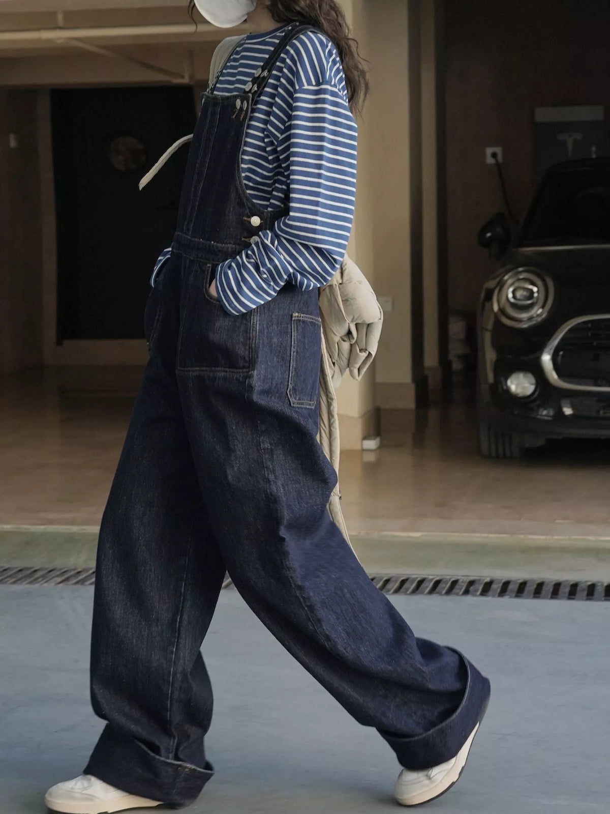 Dark-wash denim overalls with front bib, stitched seams, and relaxed wide-leg silhouette