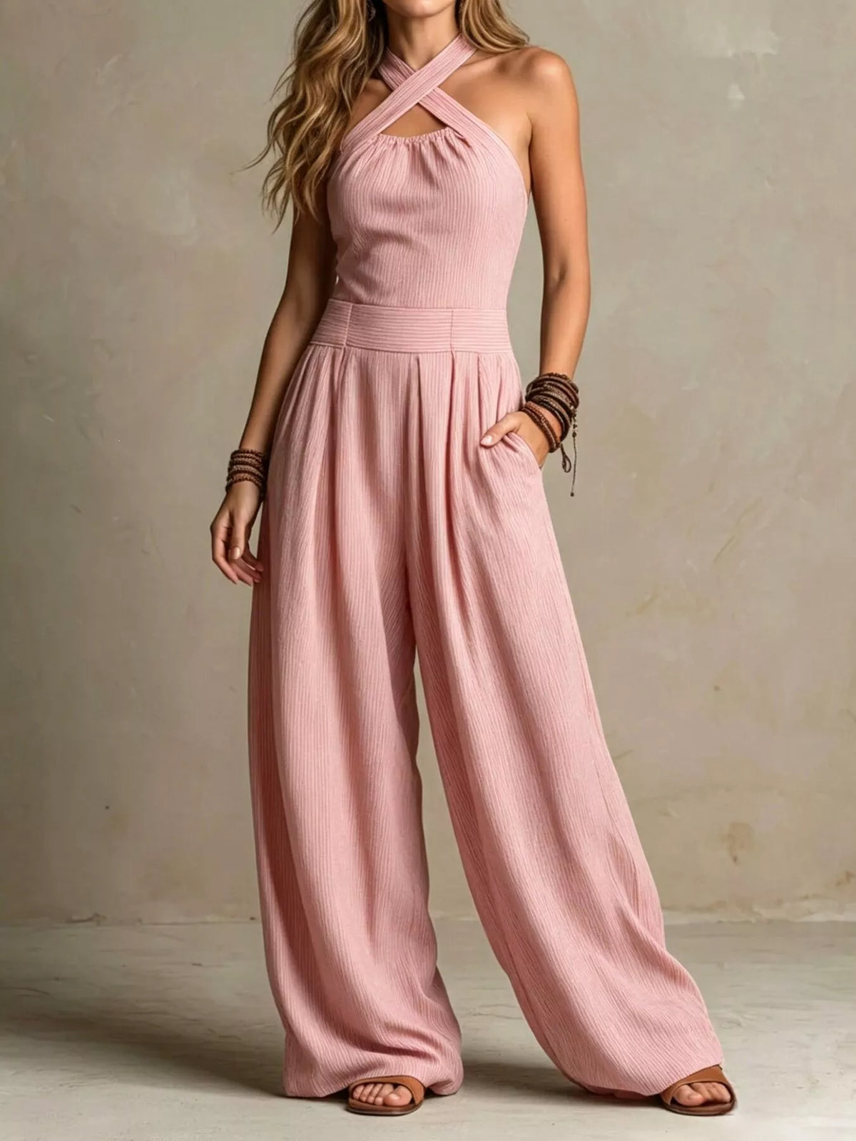 Light pink halter-neck wide-leg jumpsuit with sleeveless bodice and gathered waist.