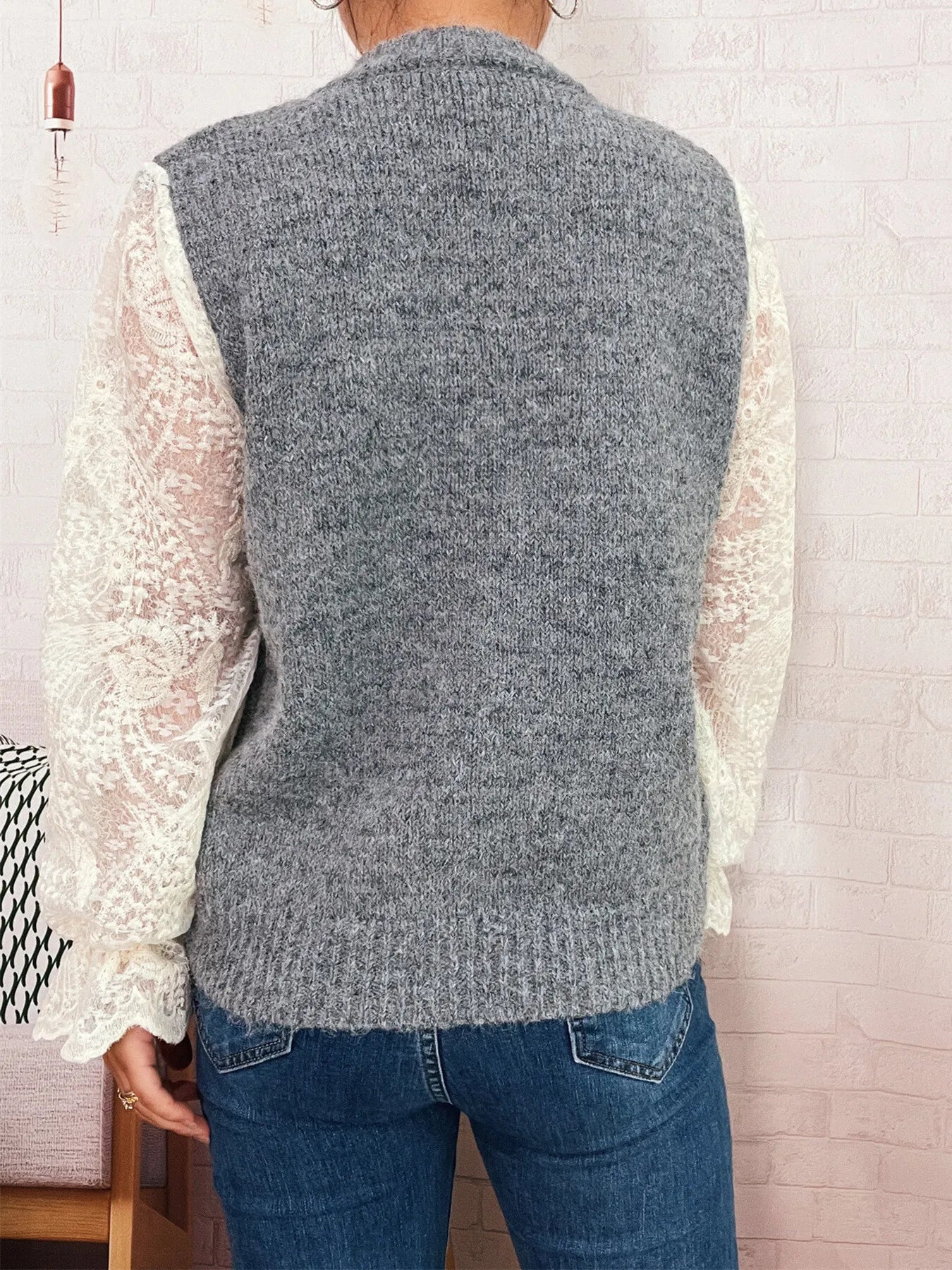 Gray knit button-up cardigan with lace sleeves, shown from back