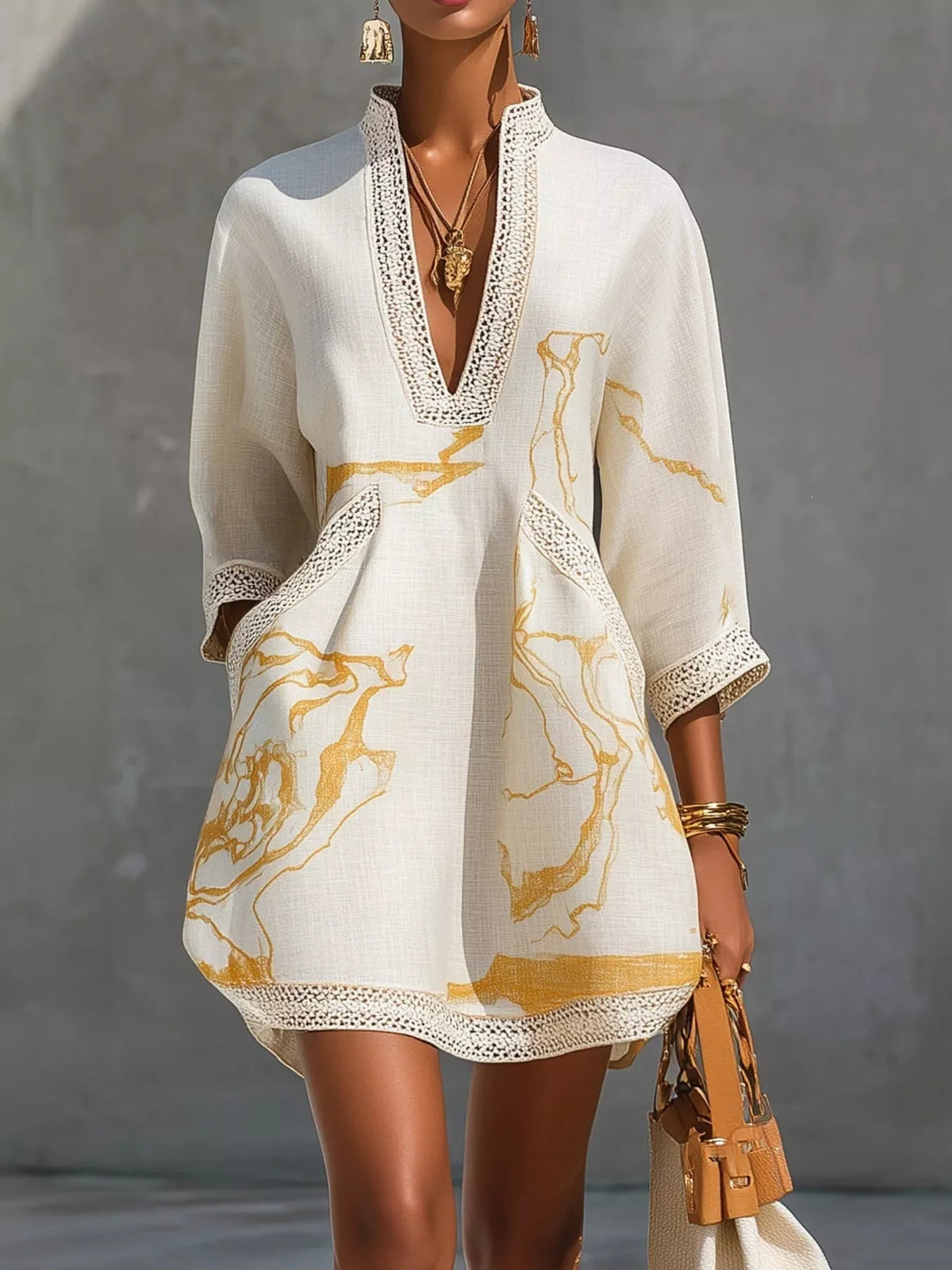 White relaxed mini dress with V-neck lace trim and gold abstract print