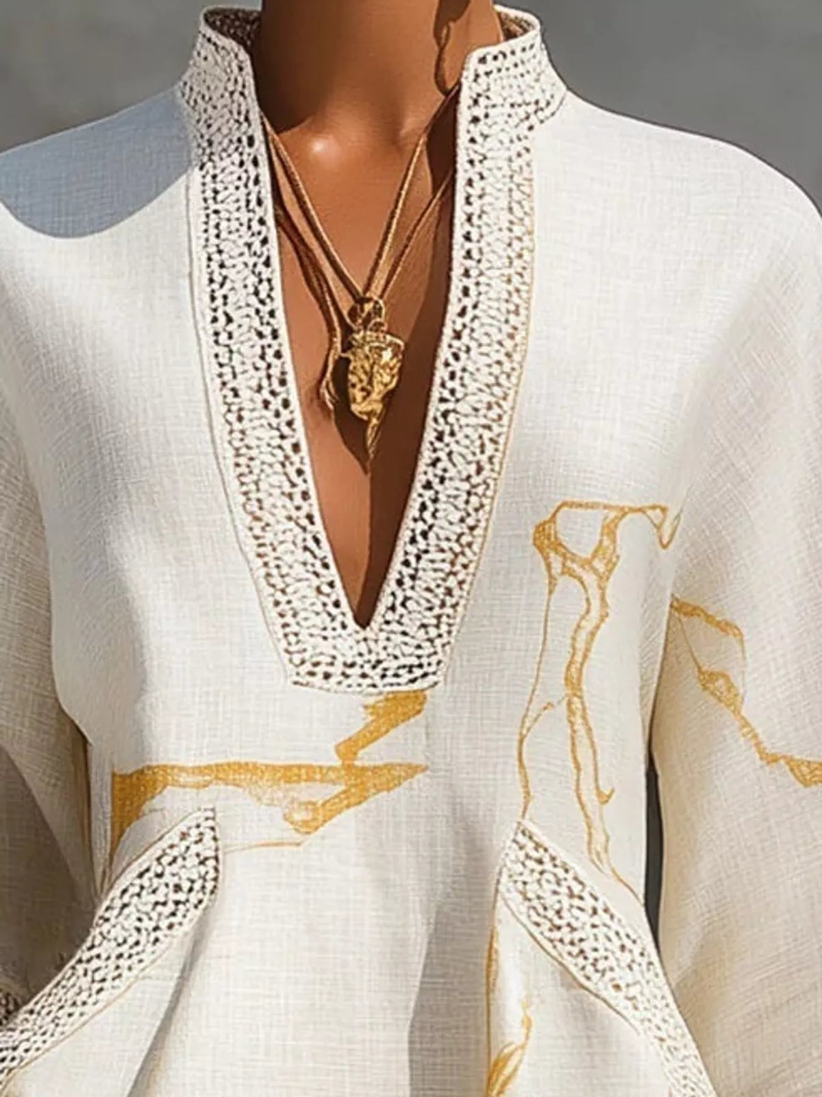 White mini dress with lace V neckline and gold abstract motif