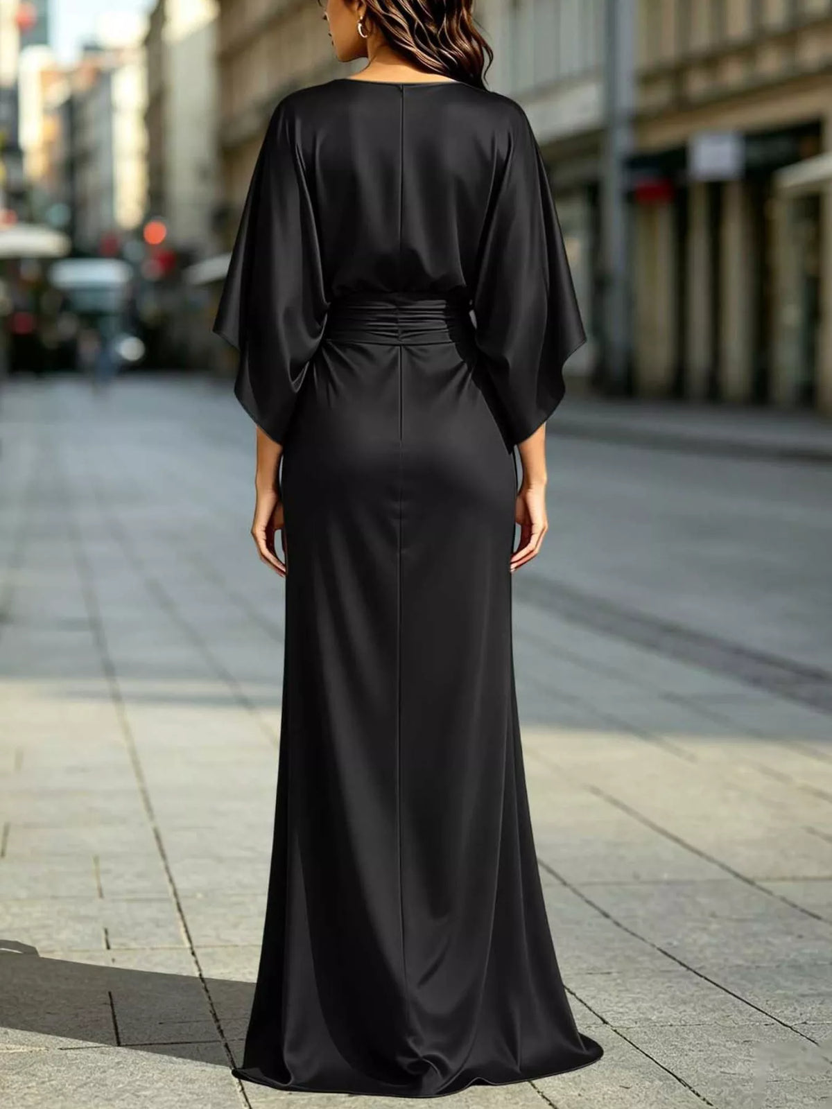 Black ruched-waist maxi dress, back view with batwing sleeves and side slit