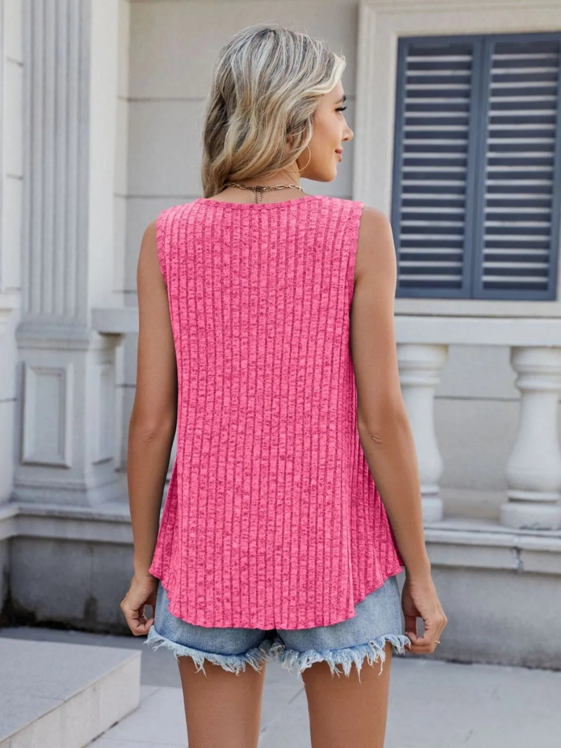 Hot pink ribbed round-neck tank, sleeveless back view with curved hem