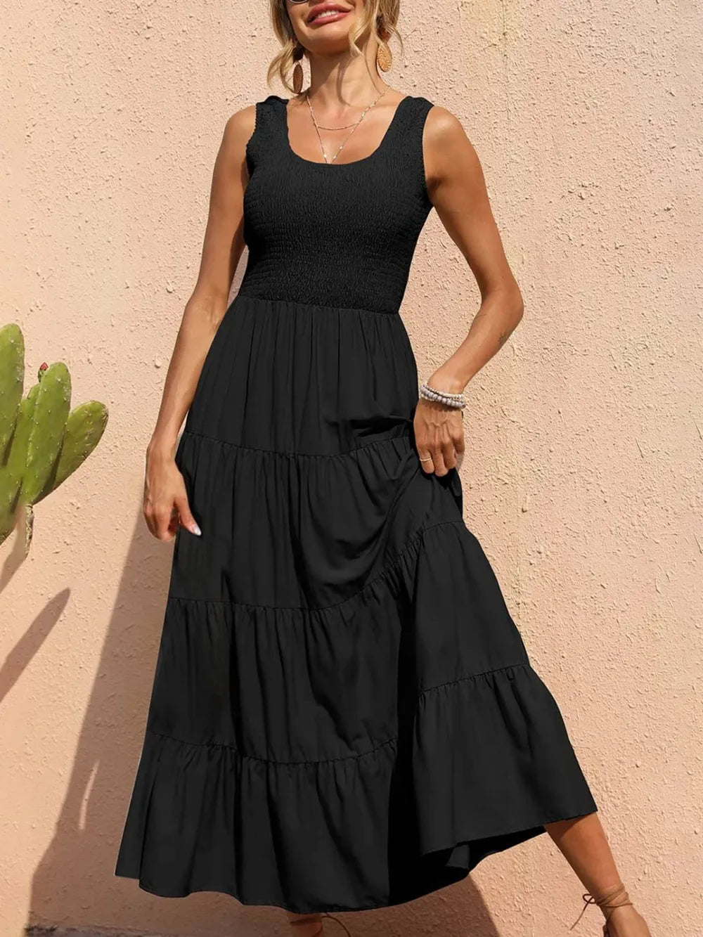 Black tiered smocked wide-strap dress with sleeveless smocked bodice and ruffled skirt tiers.
