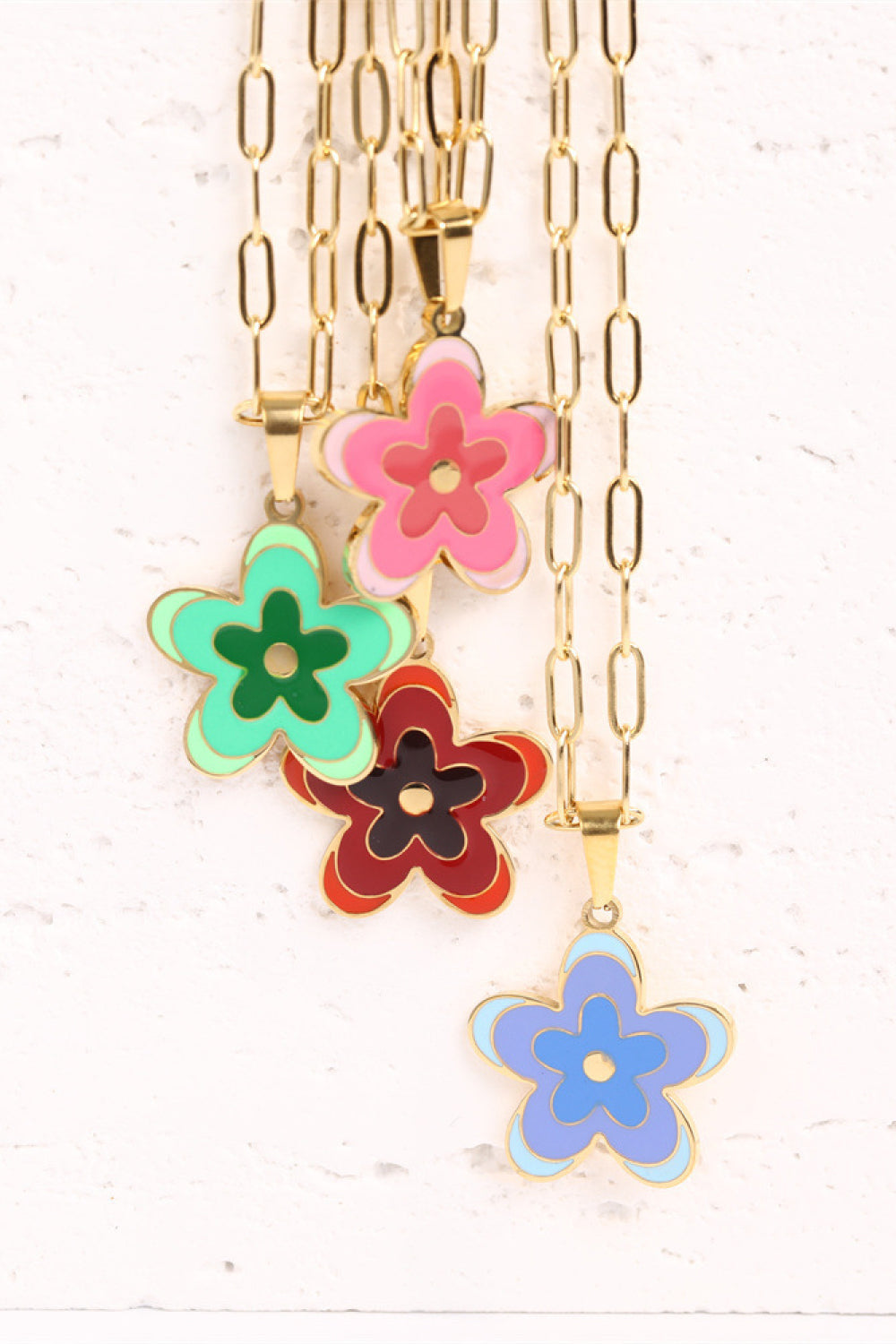 Layered gold-tone flower pendant necklace with pink, green, red, and blue charms