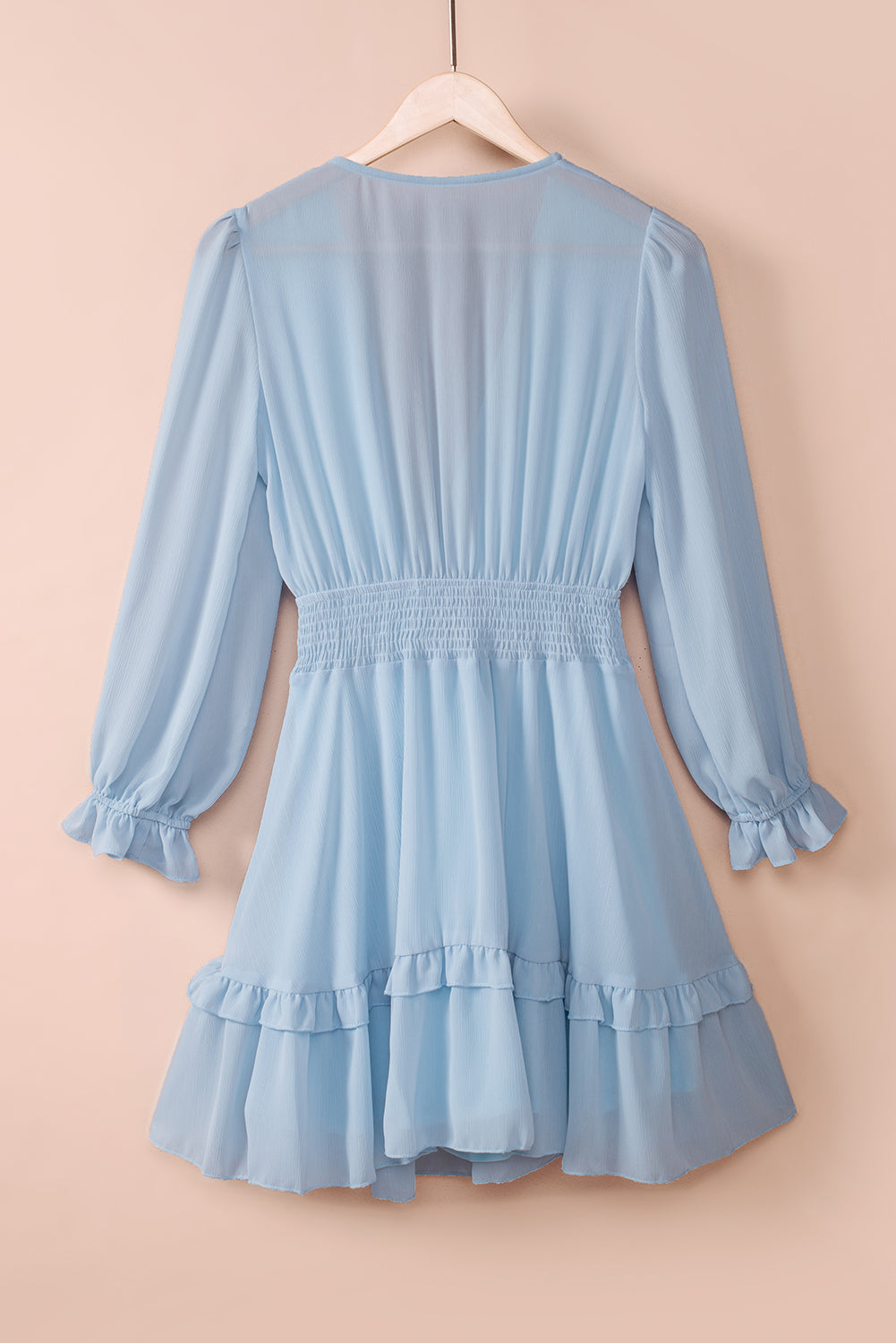 Sky blue smocked-waist flounce dress on hanger with long ruffled sleeves and tiered skirt