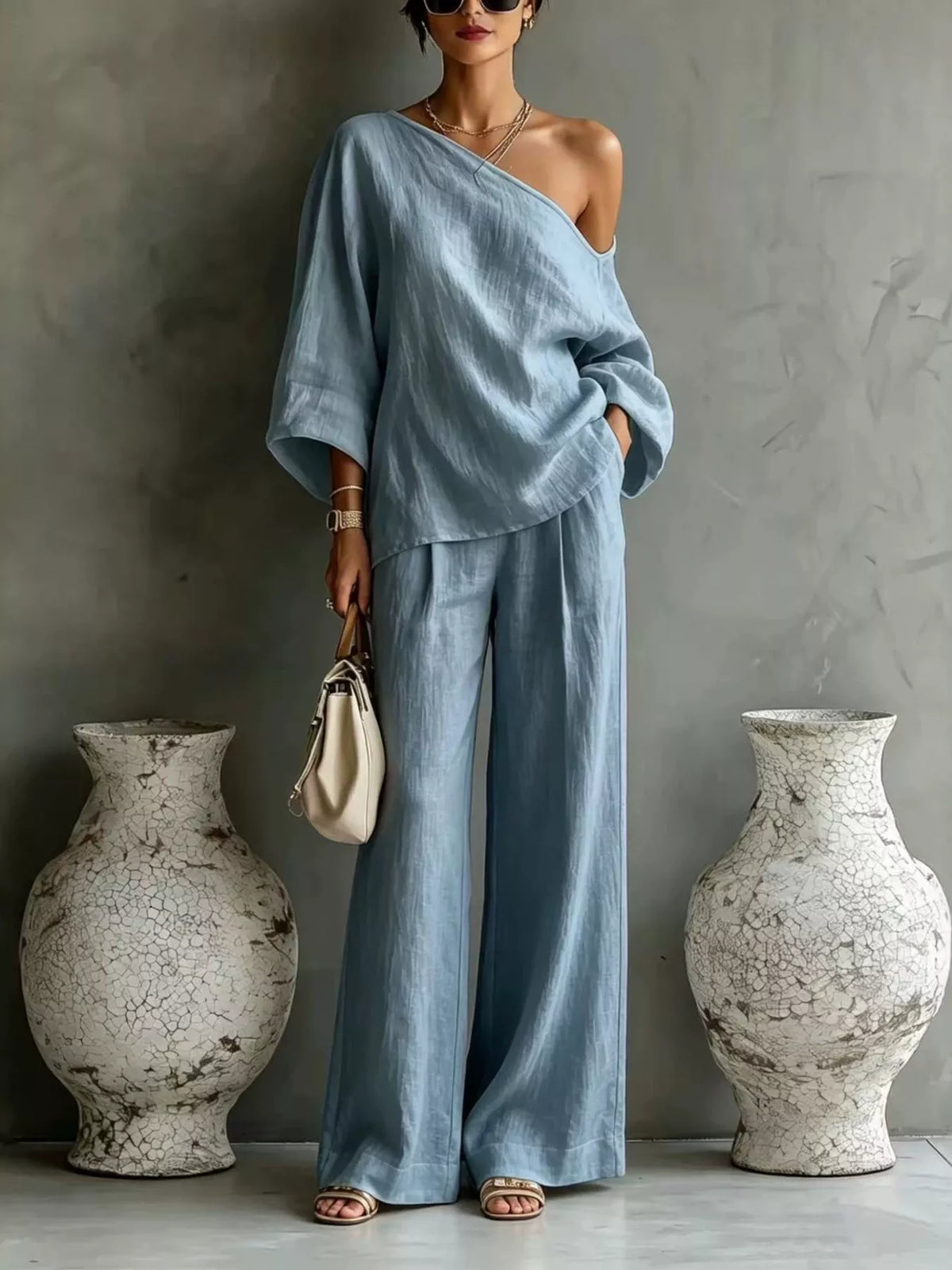 Light blue one-shoulder drape top with wide-leg matching pants set.