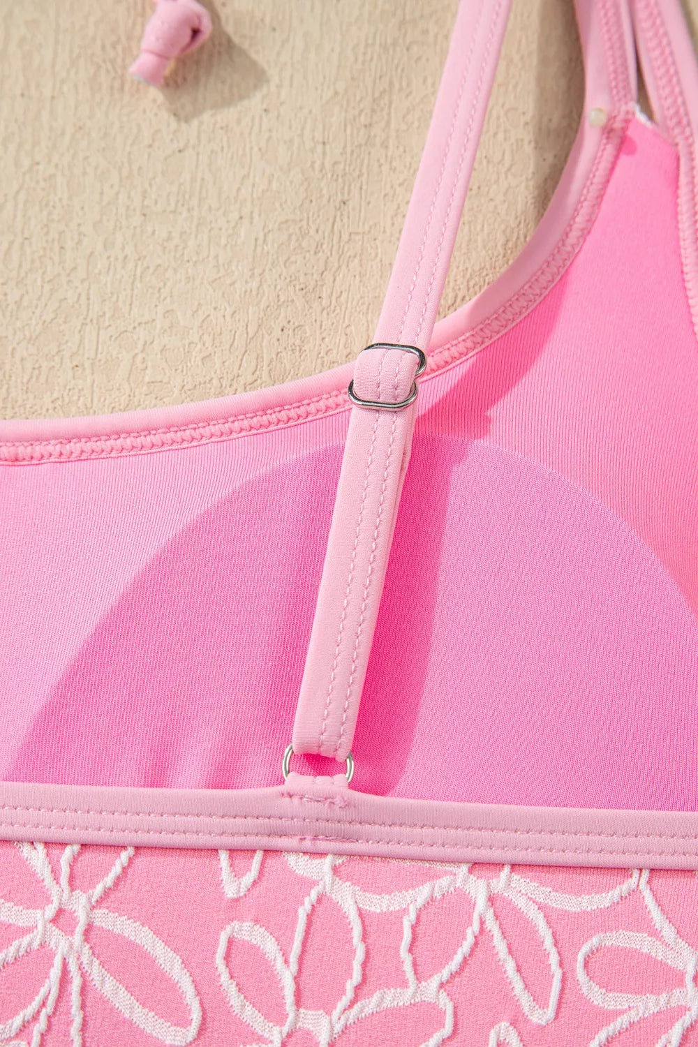 Blush pink halter one-piece swimsuit with adjustable buckle strap and floral hem
