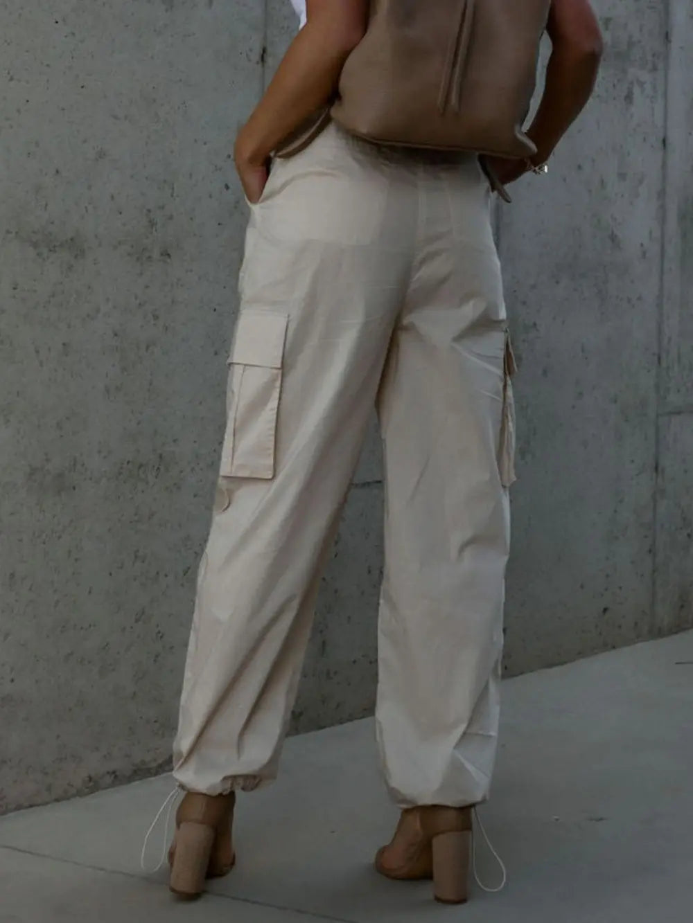 Beige wide-leg drawstring pants with front pockets and cuffed hems