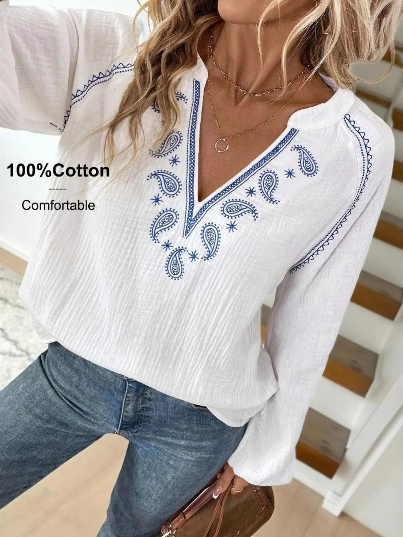 Long-sleeve blouse in white with blue paisley embroidery at the chest and neckline